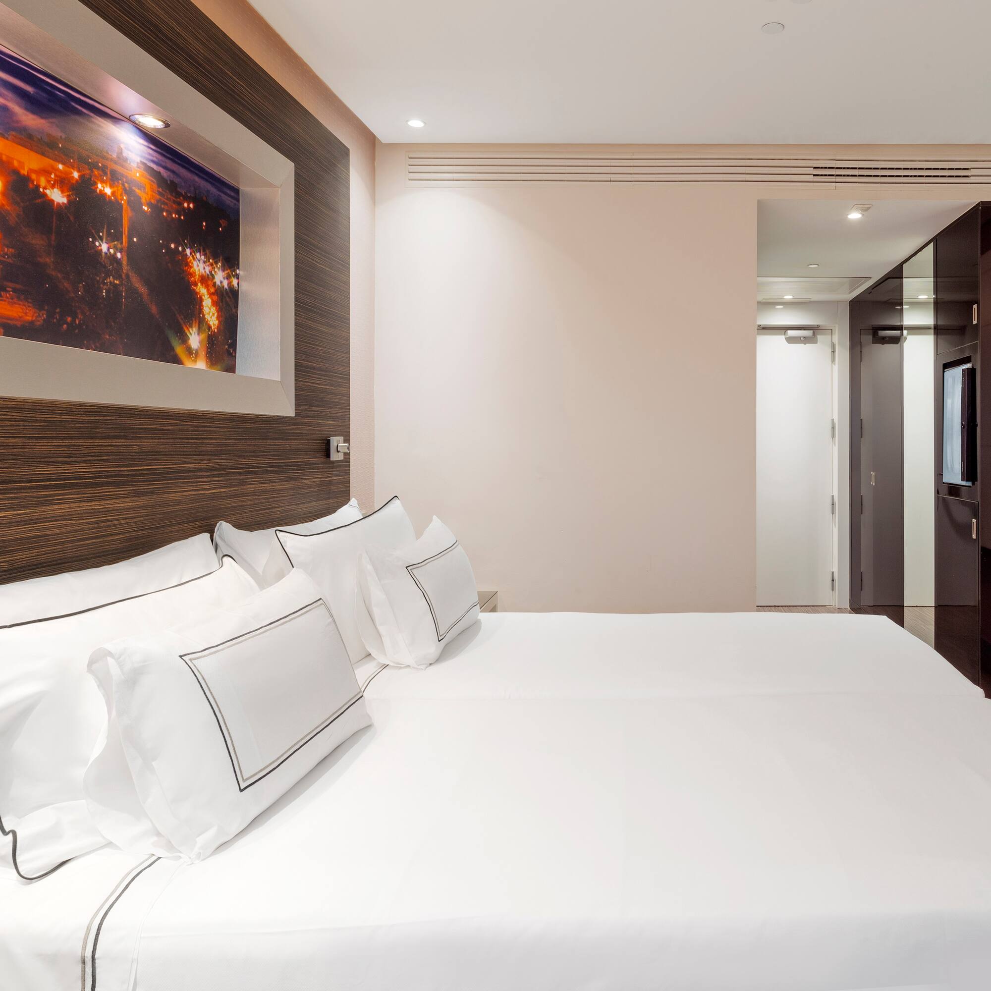 a bed with white sheets and pillows