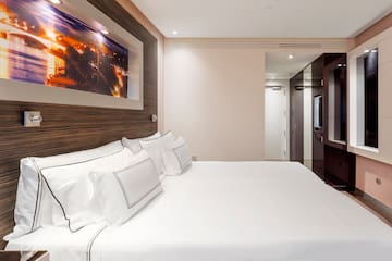 a bed with white sheets and pillows