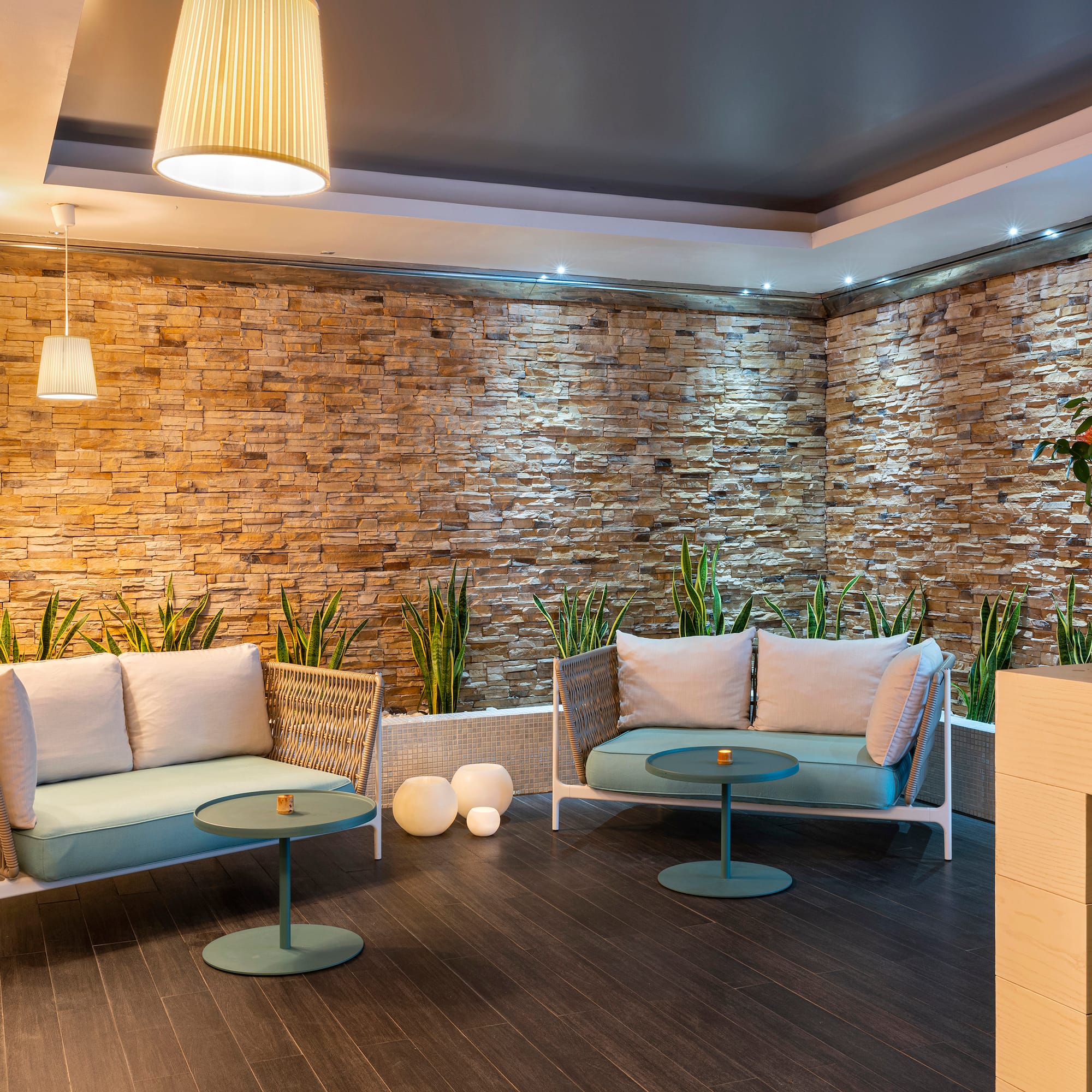 a room with a stone wall and a couch and a table