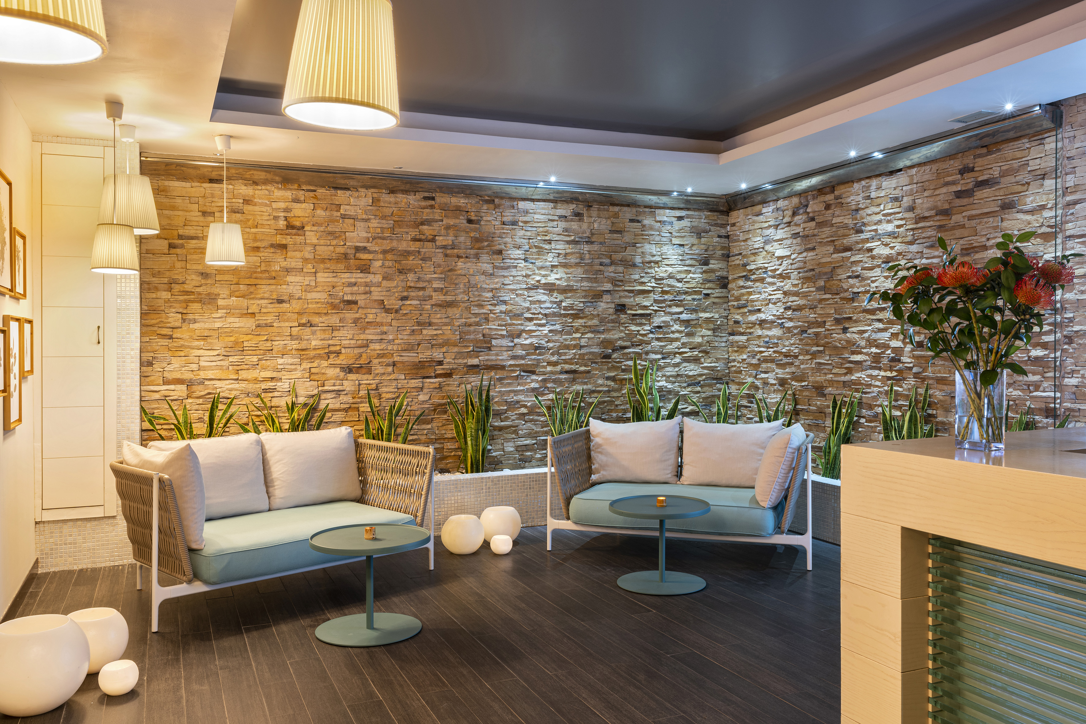 a room with a stone wall and a couch and a table