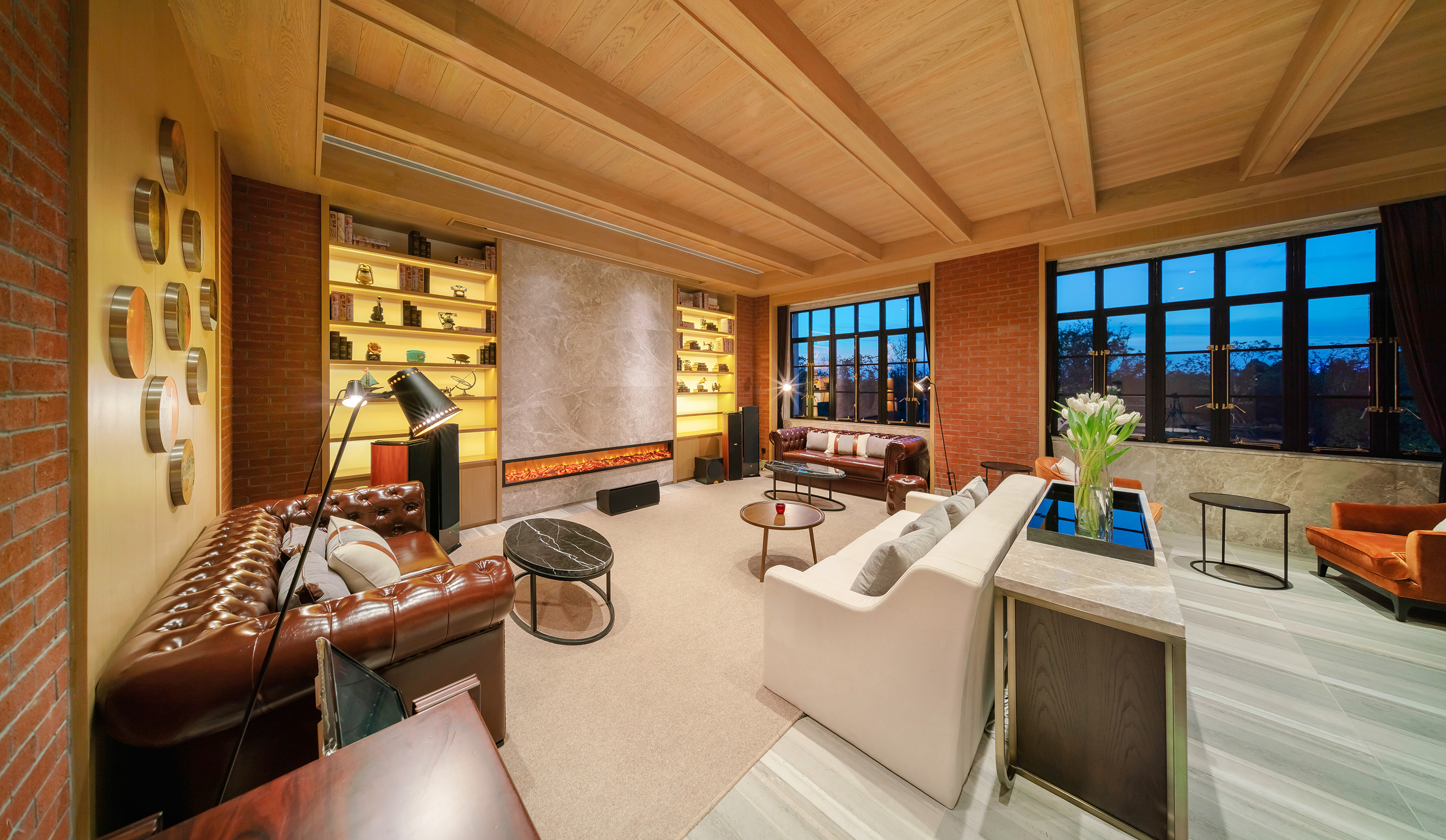 Industrial living room, brick walls, leather sofas, wood ceiling, modern fireplace.