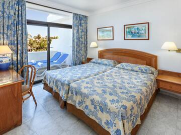 a bedroom with two beds and a chair