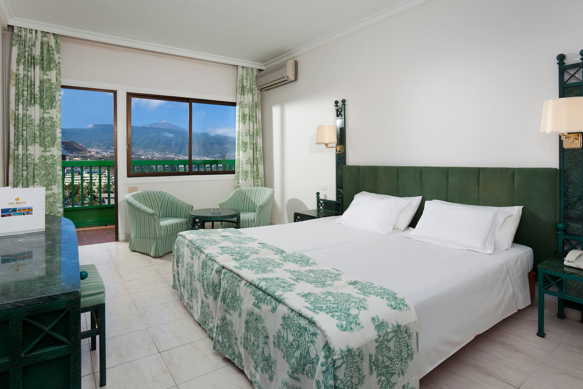 a bedroom with a bed and chairs