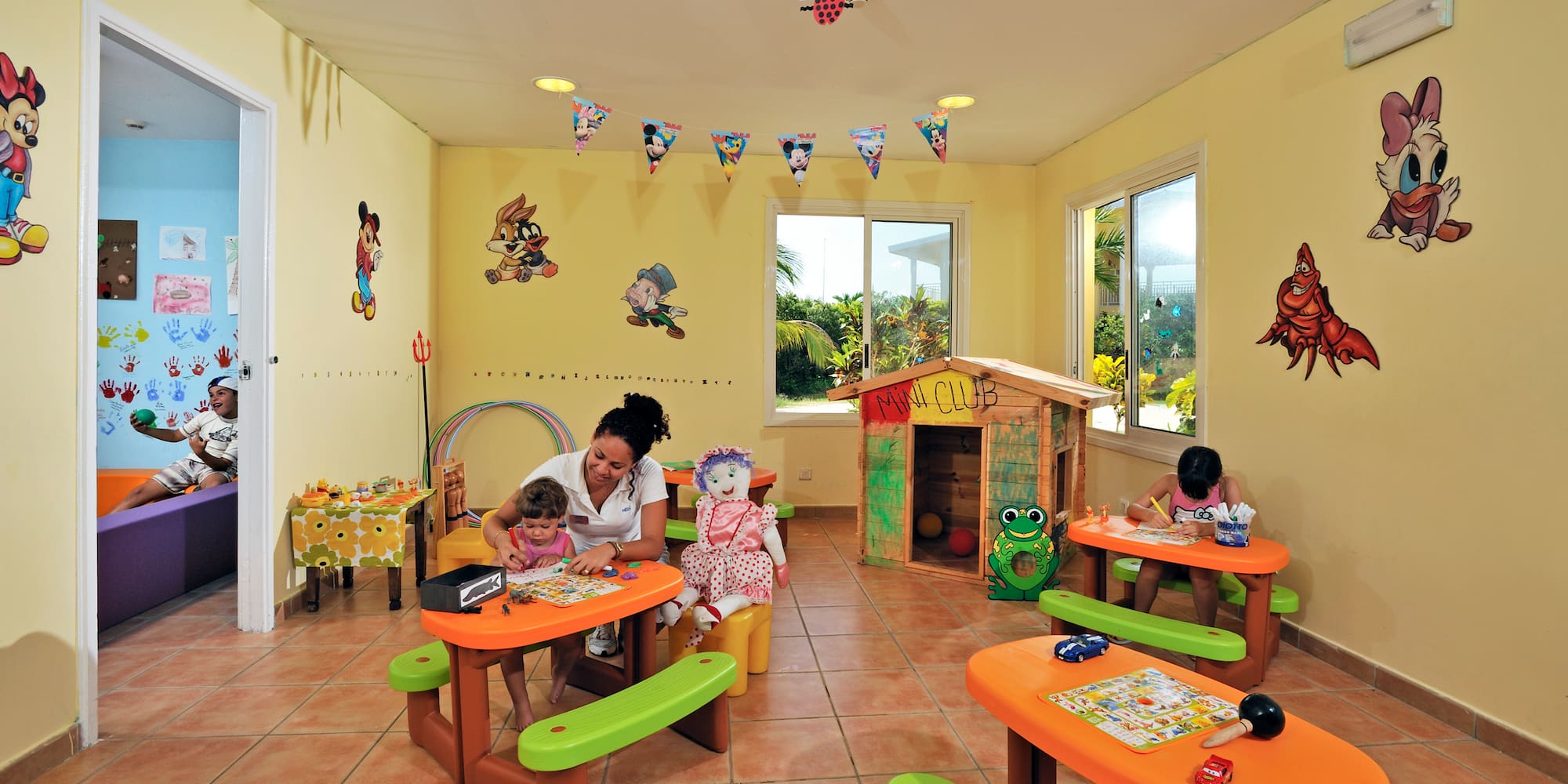 a woman and children sitting at tables in a room