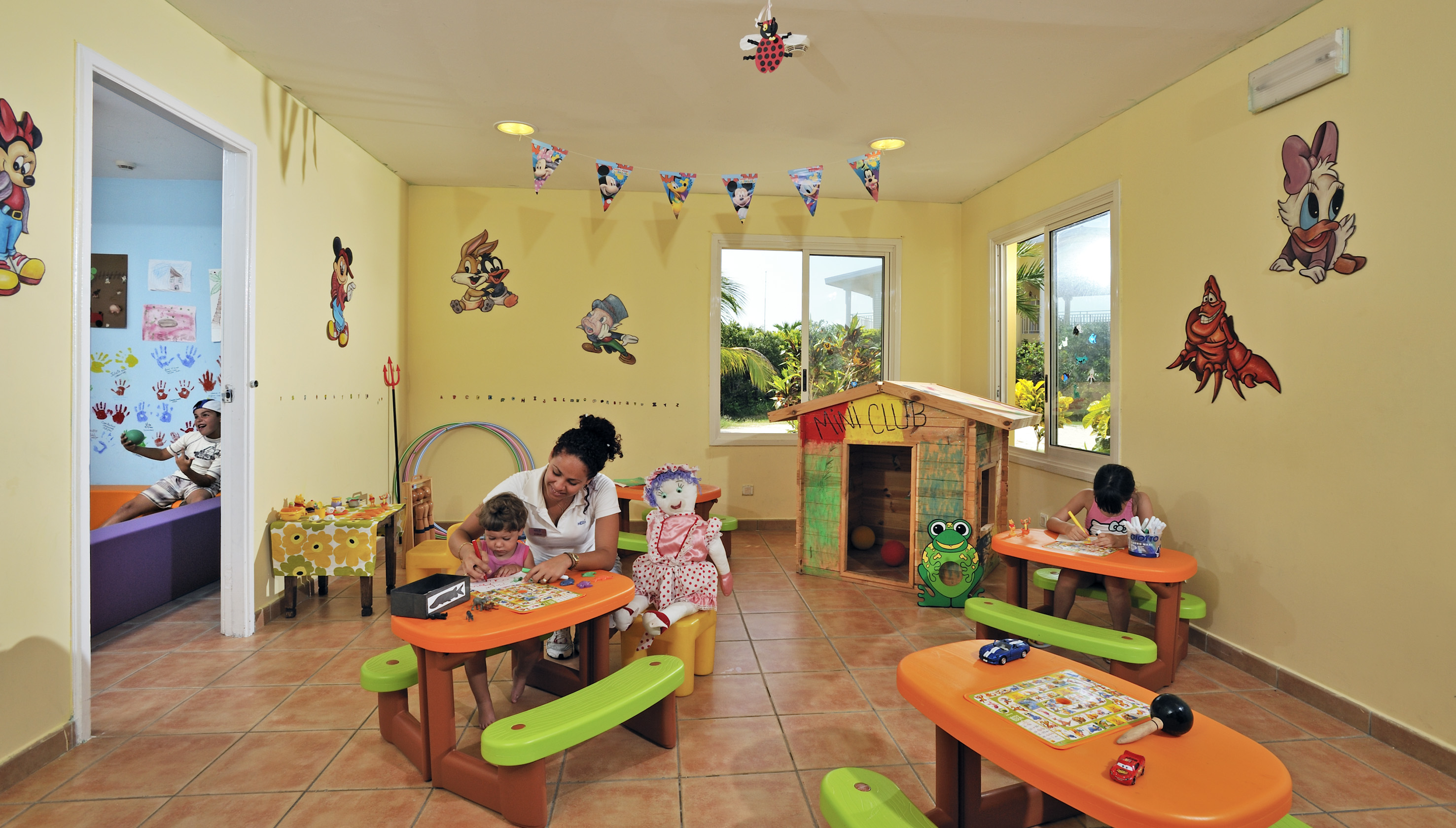 a woman and children sitting at tables in a room