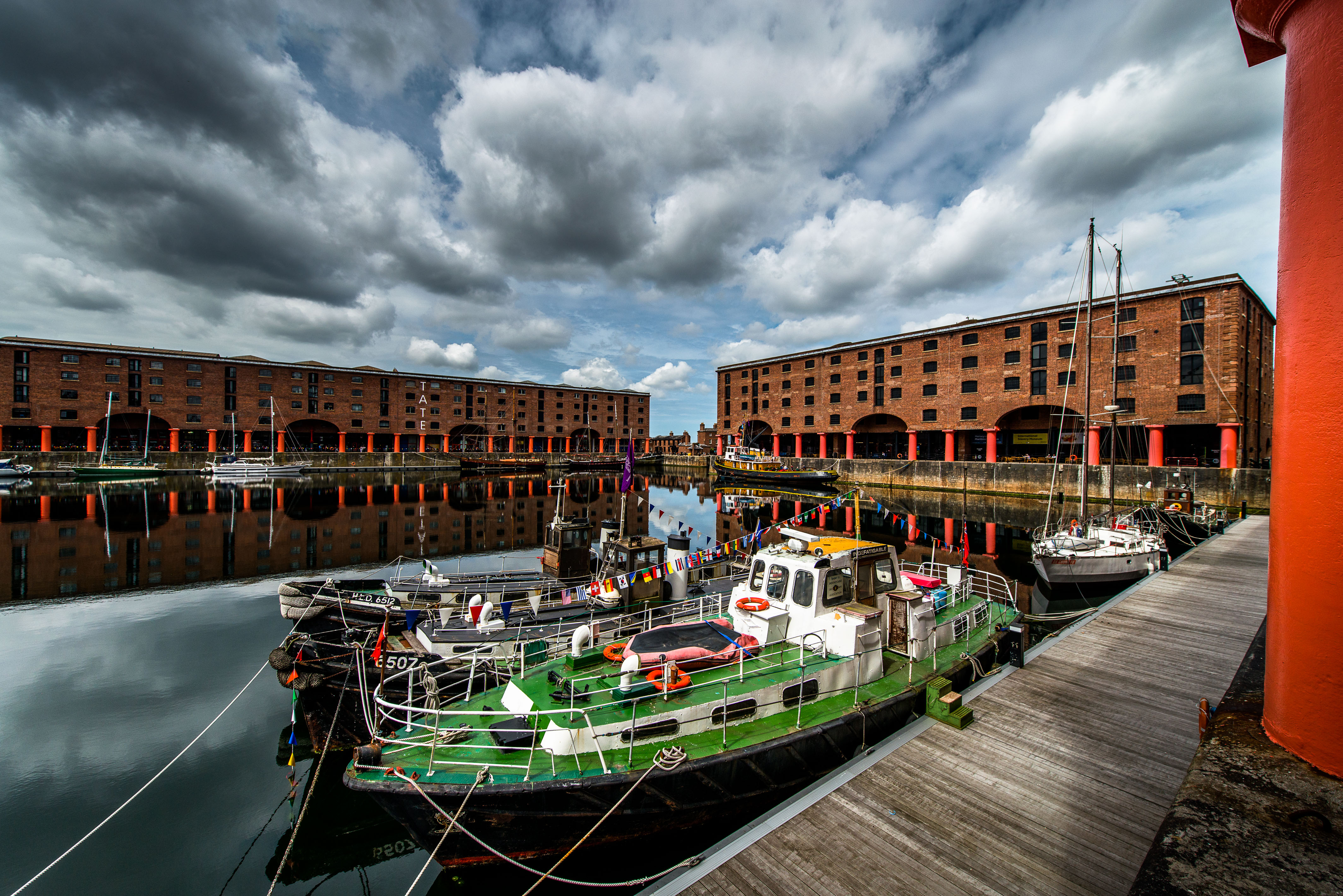 boats in a harbor with buildings and a dock