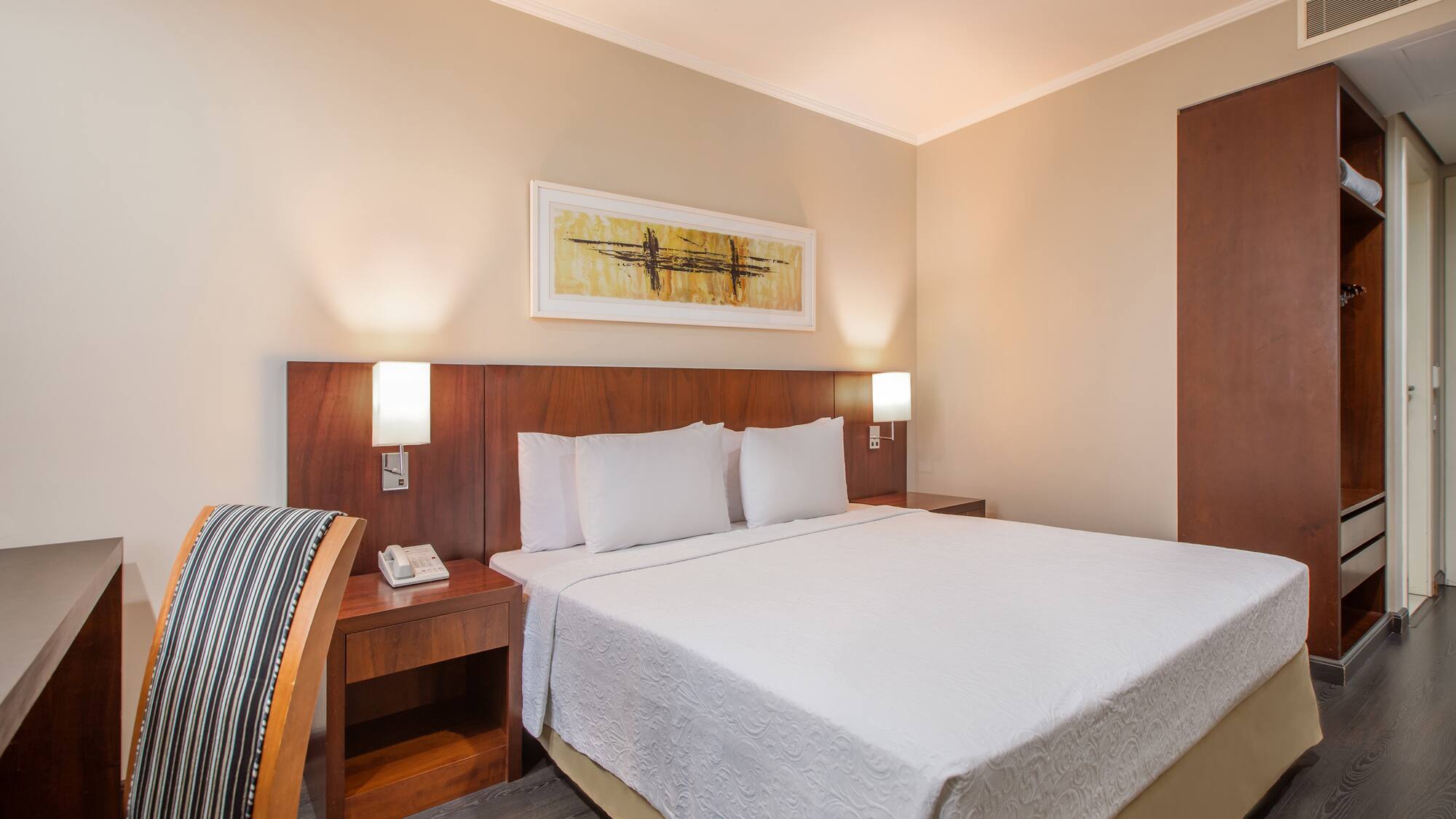 a bed with white sheets and a wood headboard