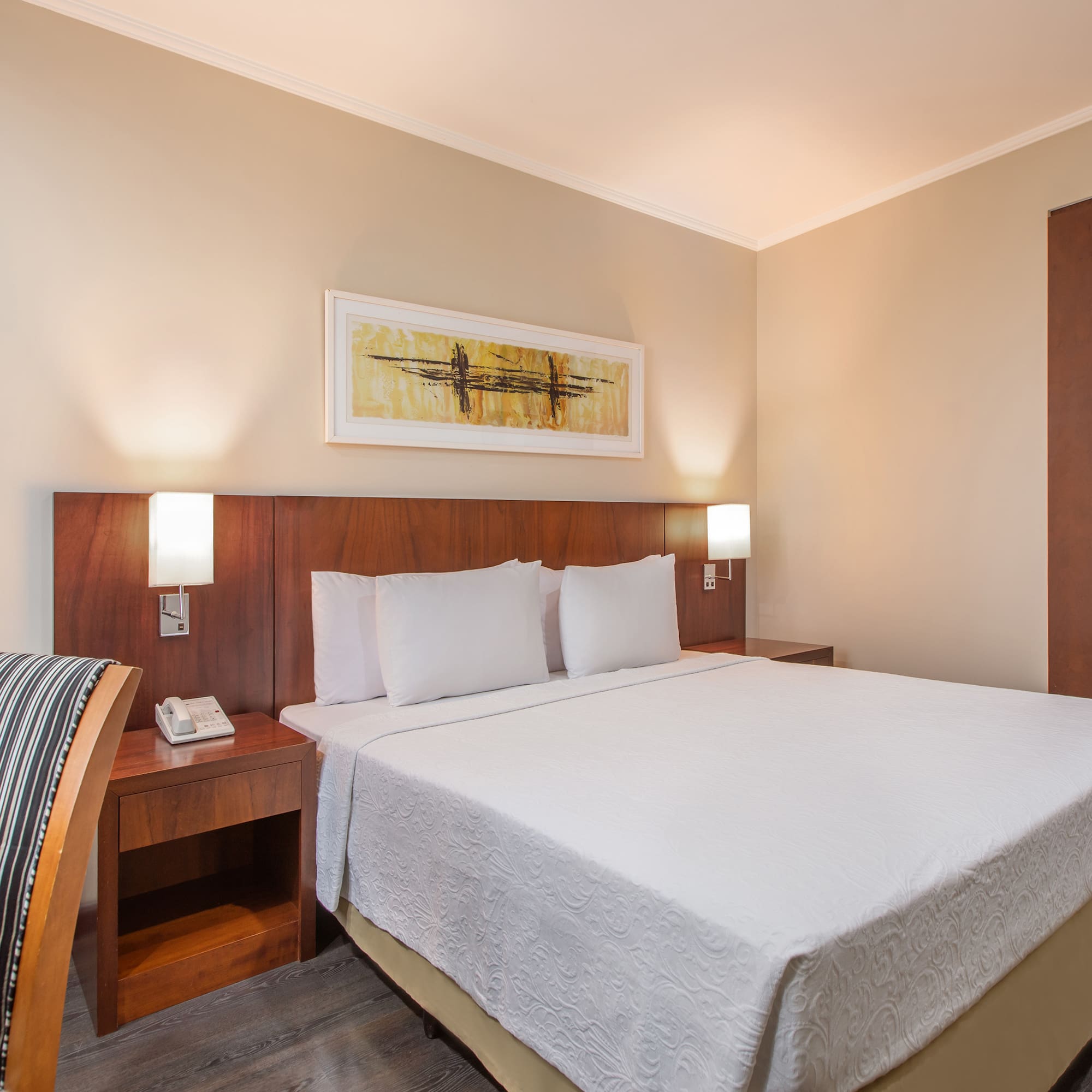 a bed with white sheets and a wood headboard