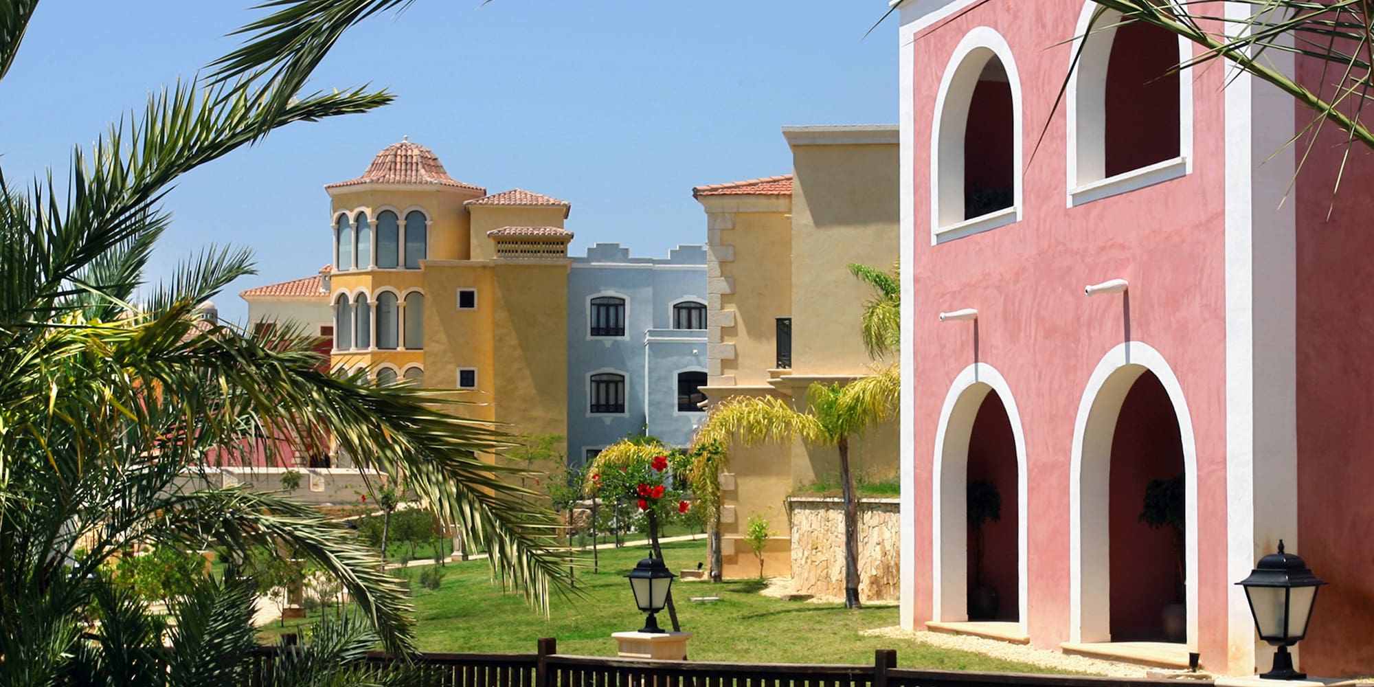a group of buildings with palm trees