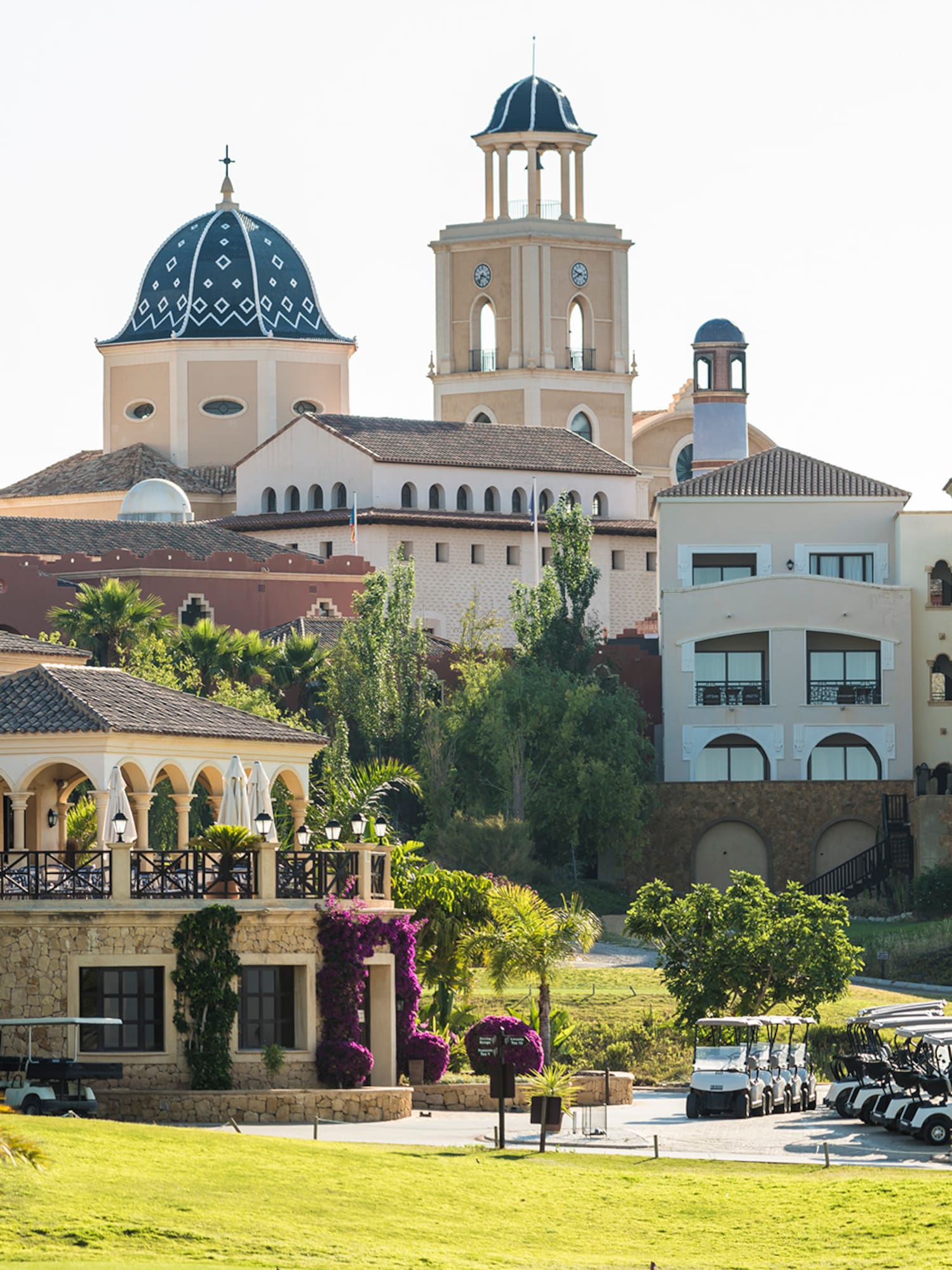 a golf course with golf carts parked in front of a golf course
