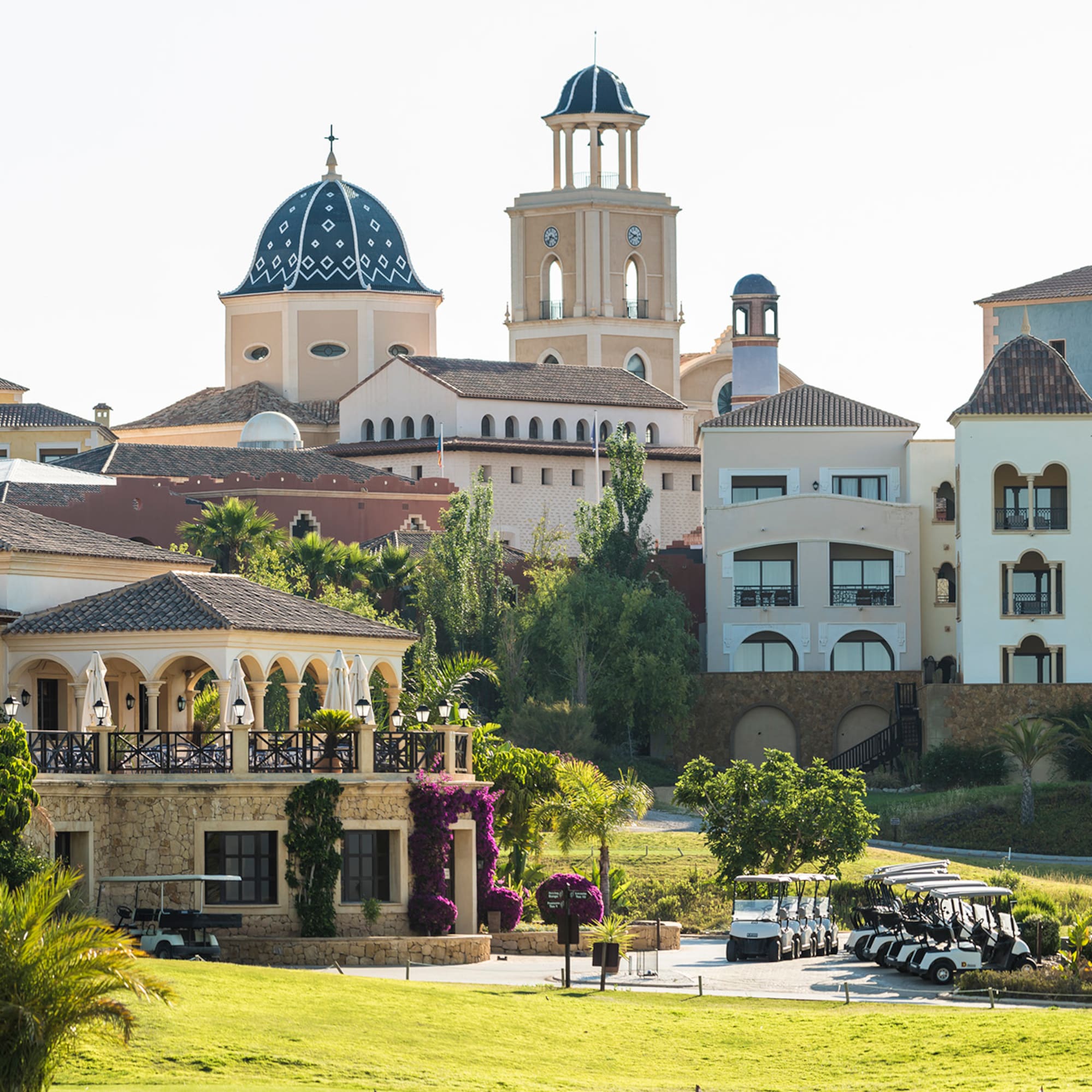 a golf course with golf carts parked in front of a golf course