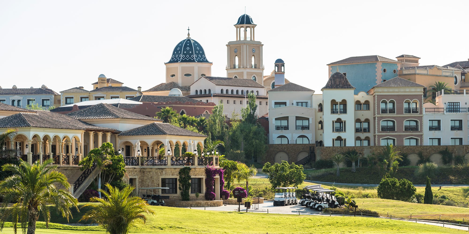 a golf course with golf carts parked in front of a golf course