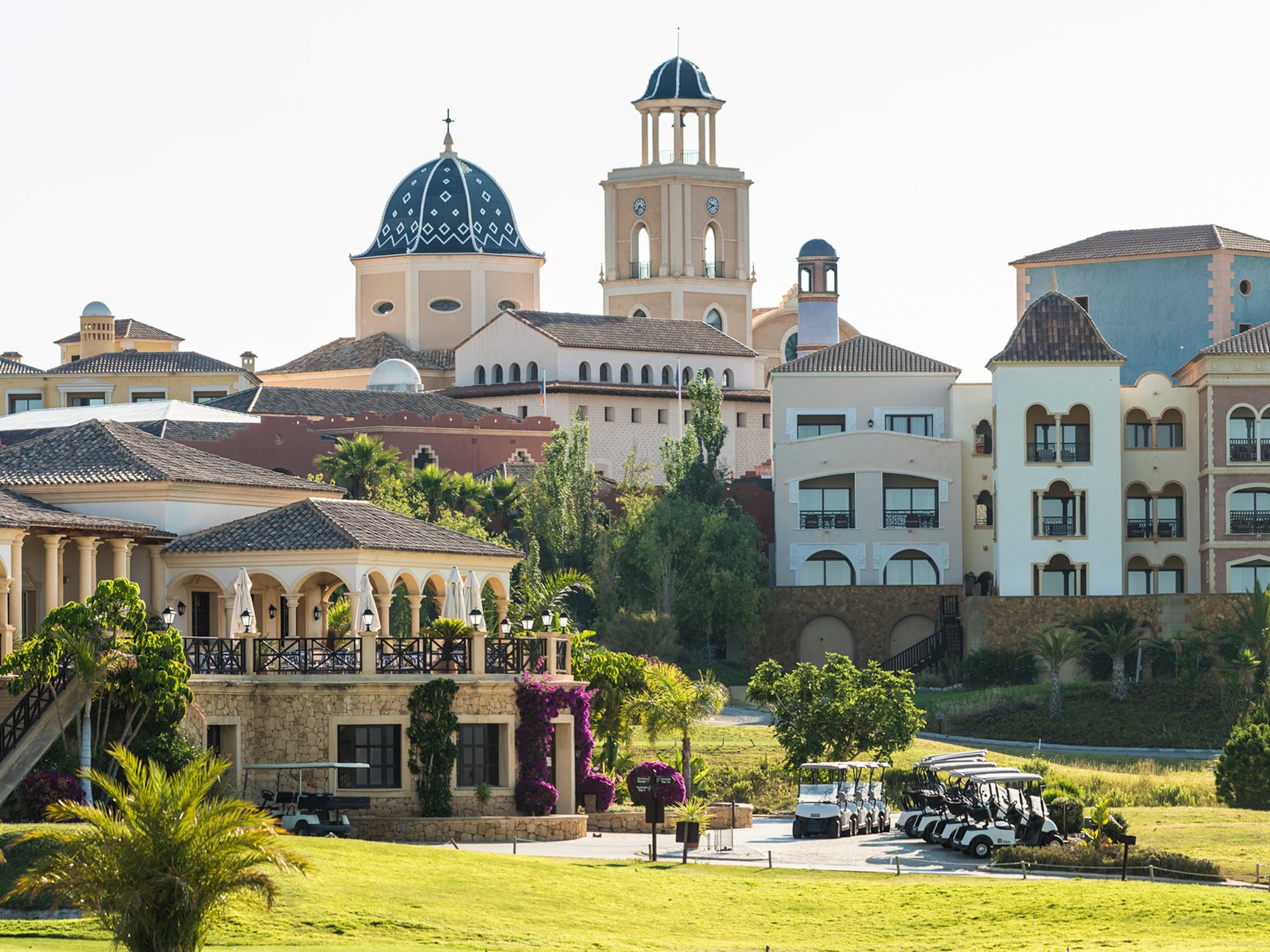 a golf course with golf carts parked in front of a golf course