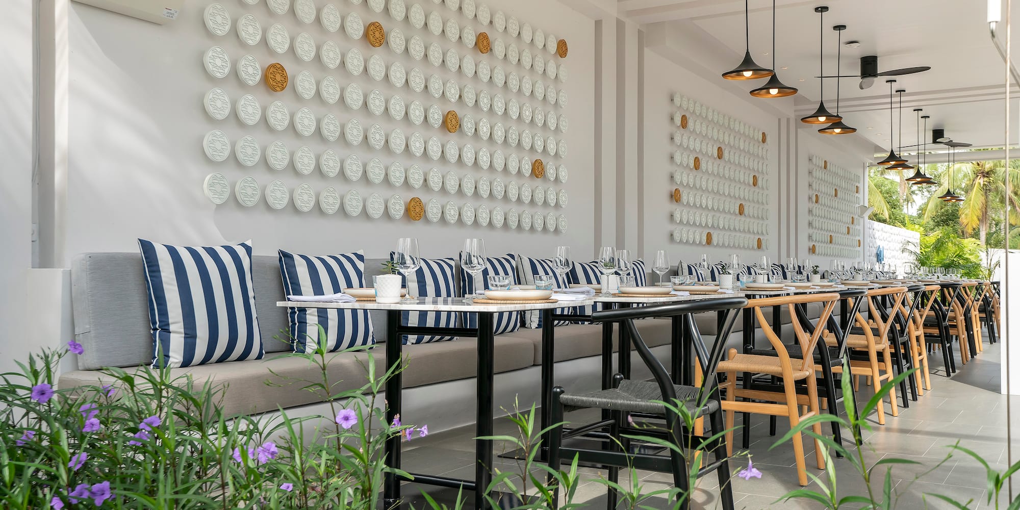 a long table with chairs and a wall of plates