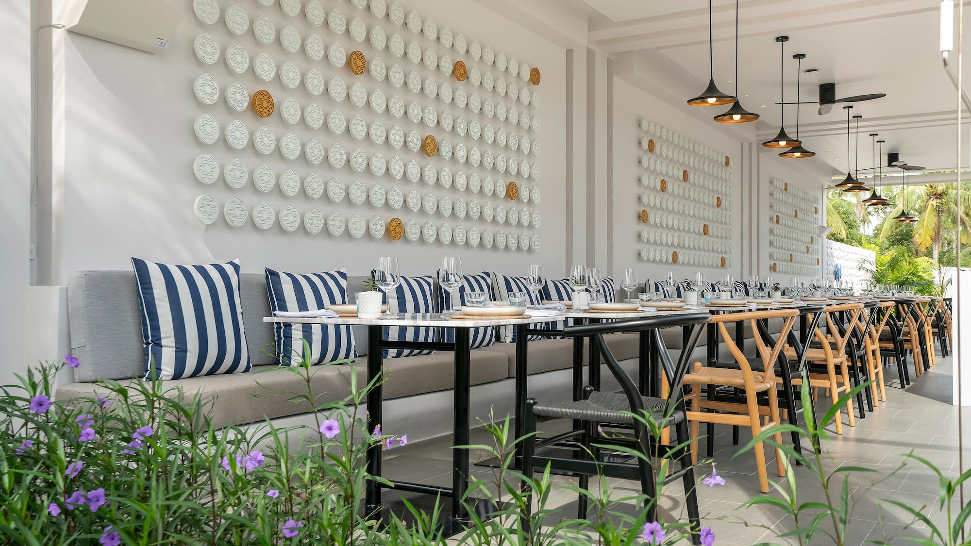 a long table with chairs and a wall of plates