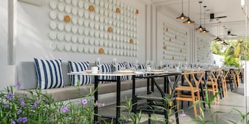 a long table with chairs and a wall of plates