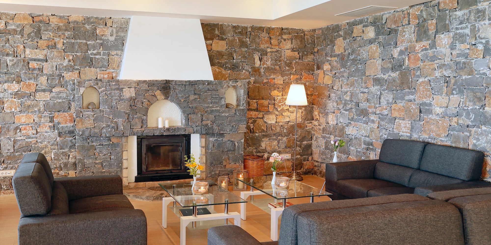 a living room with a stone wall and couches
