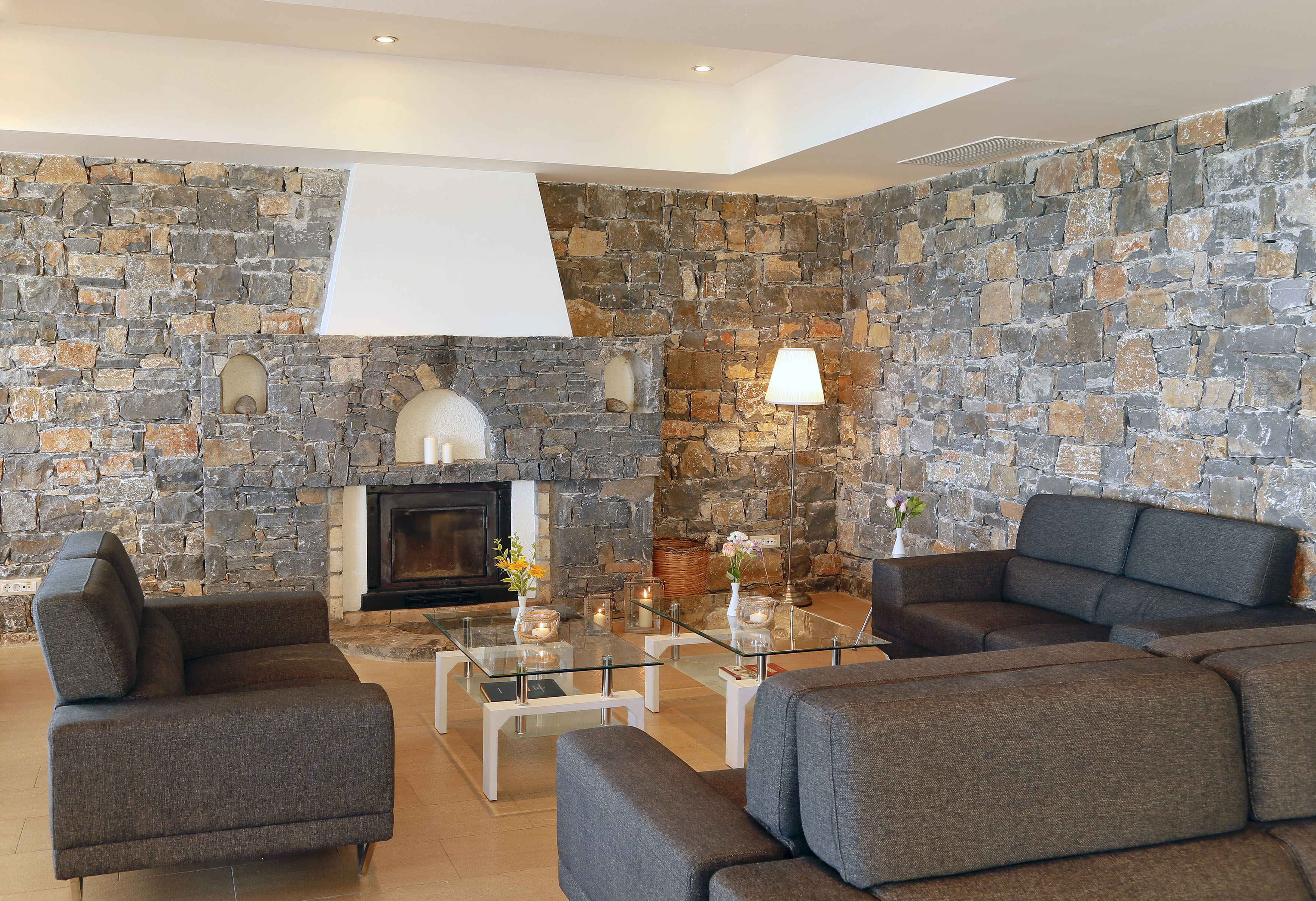 a living room with a stone wall and couches