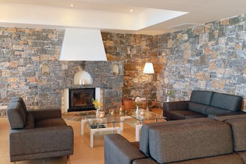 a living room with a stone wall and couches