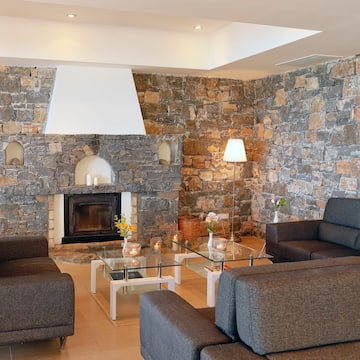 a living room with a stone wall and couches
