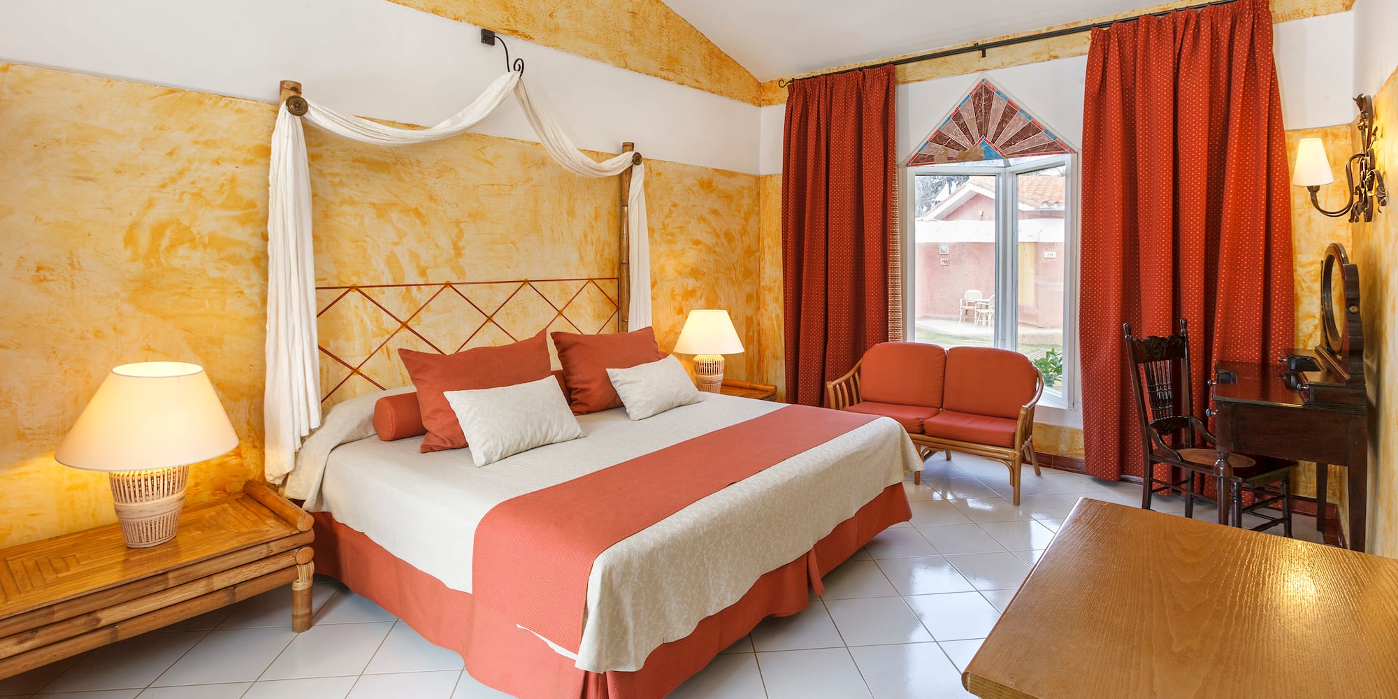 a room with a bed and chairs