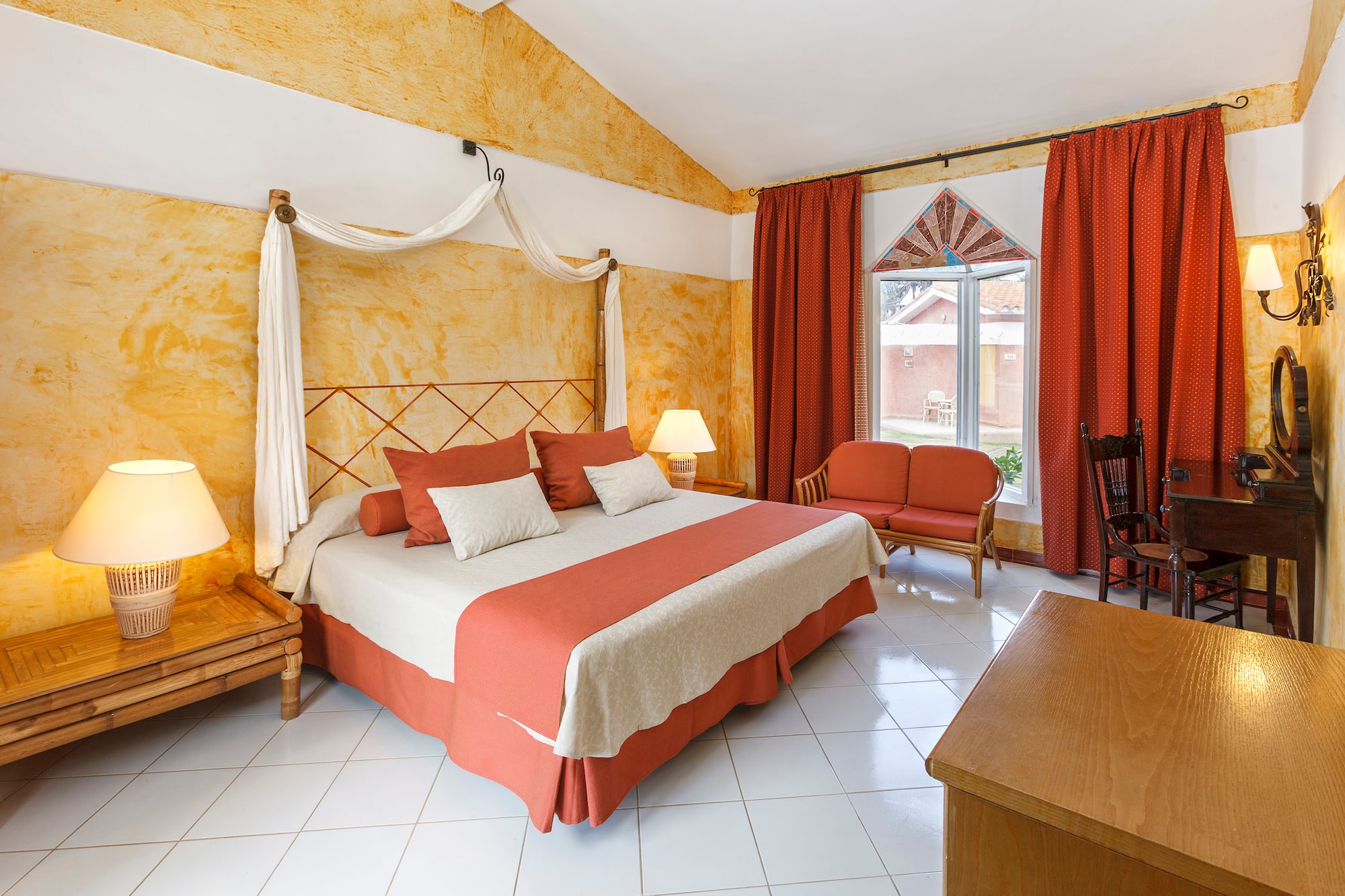 a room with a bed and chairs