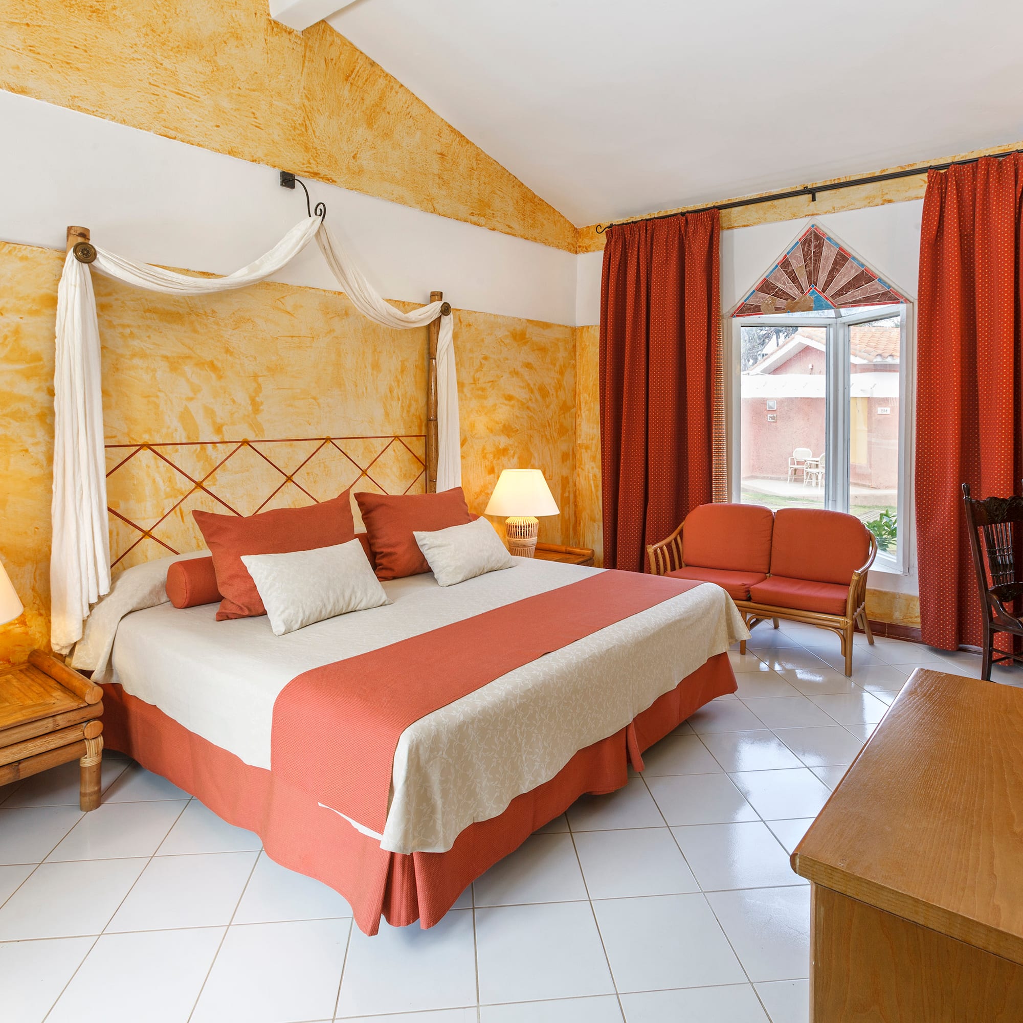 a room with a bed and chairs