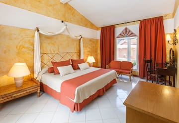 a room with a bed and chairs