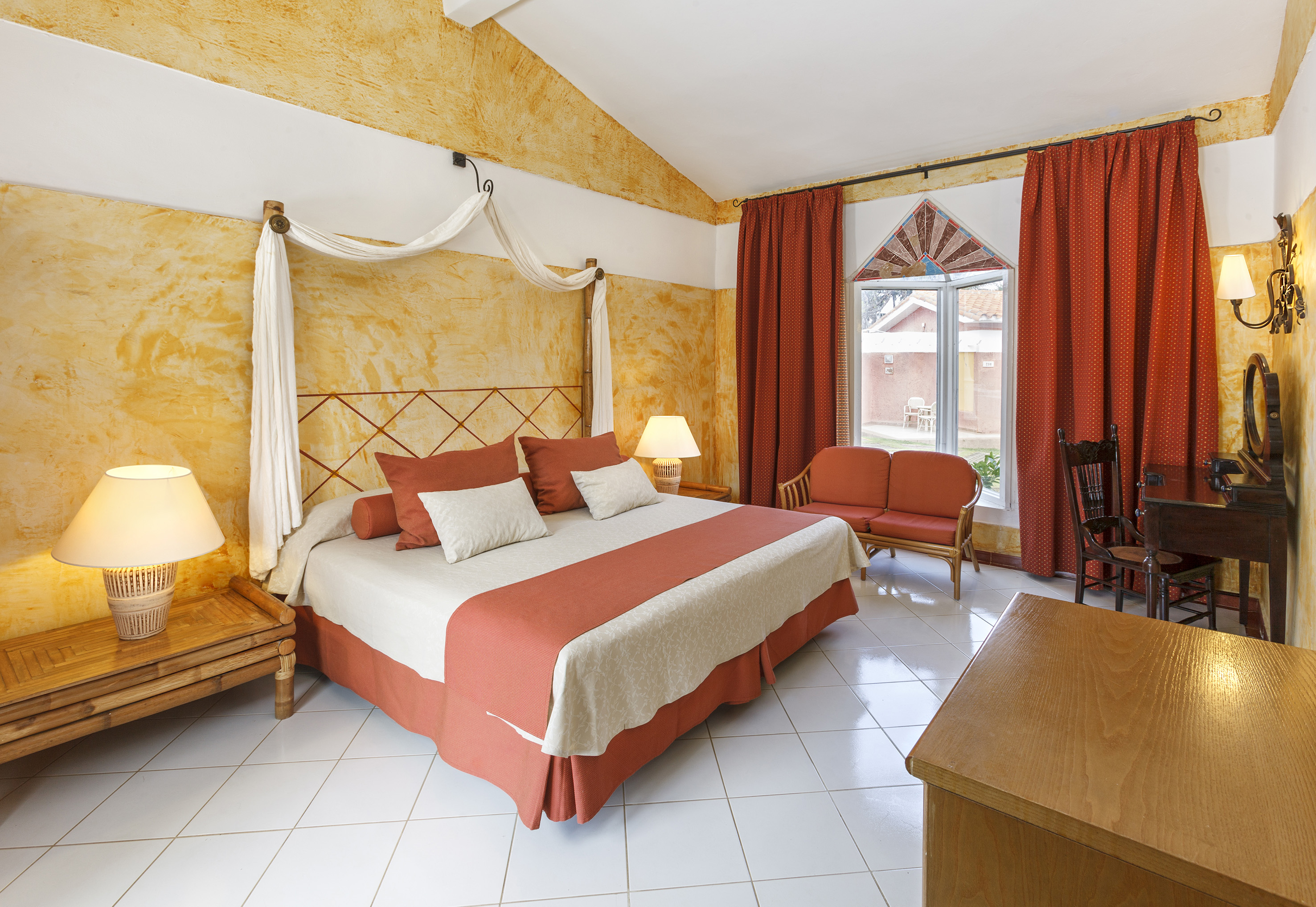 a room with a bed and chairs