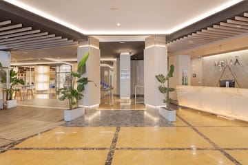 a lobby with a reception desk and plants