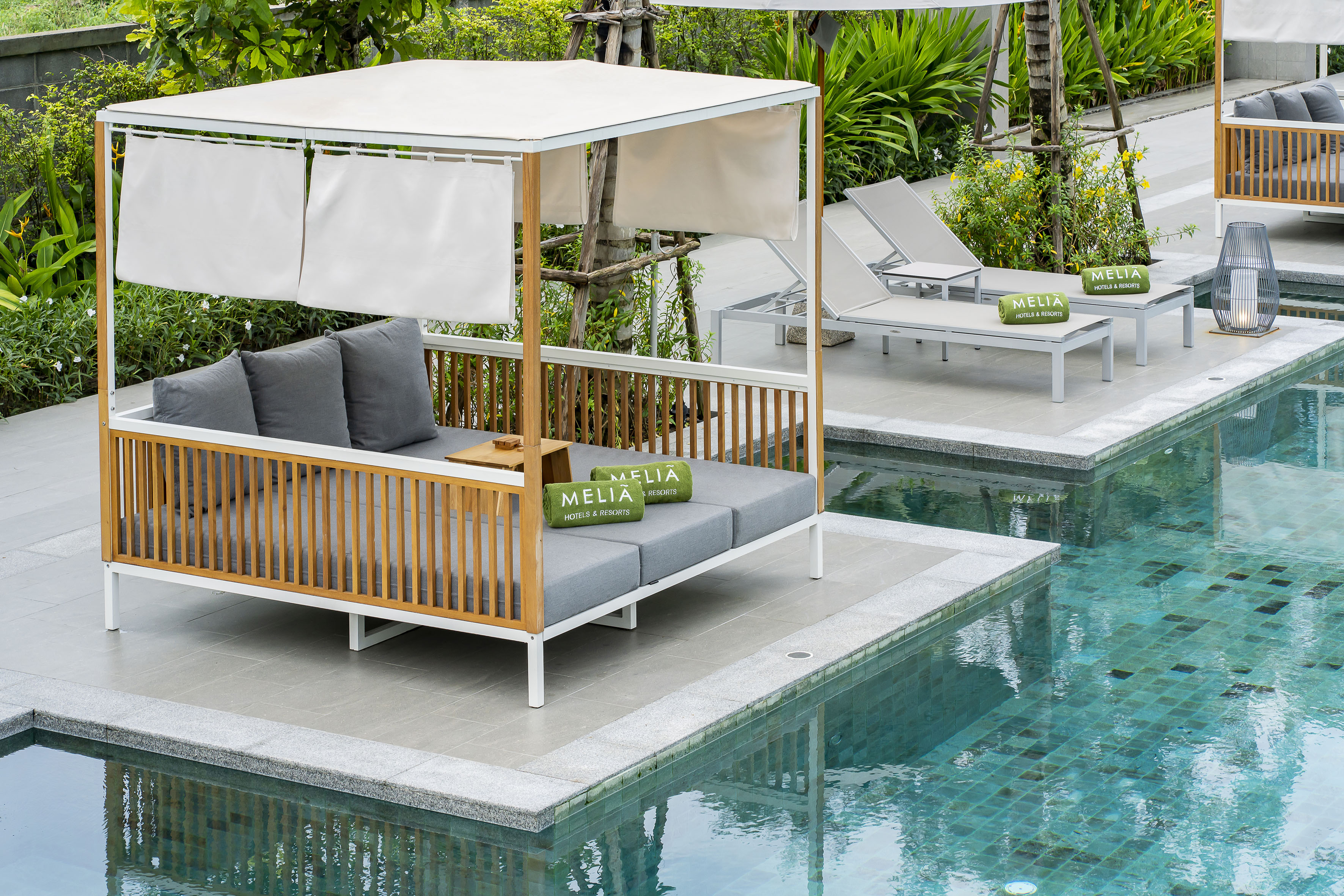 Meliá Hotels resort pool with a cabana, sun loungers, and tropical landscaping.