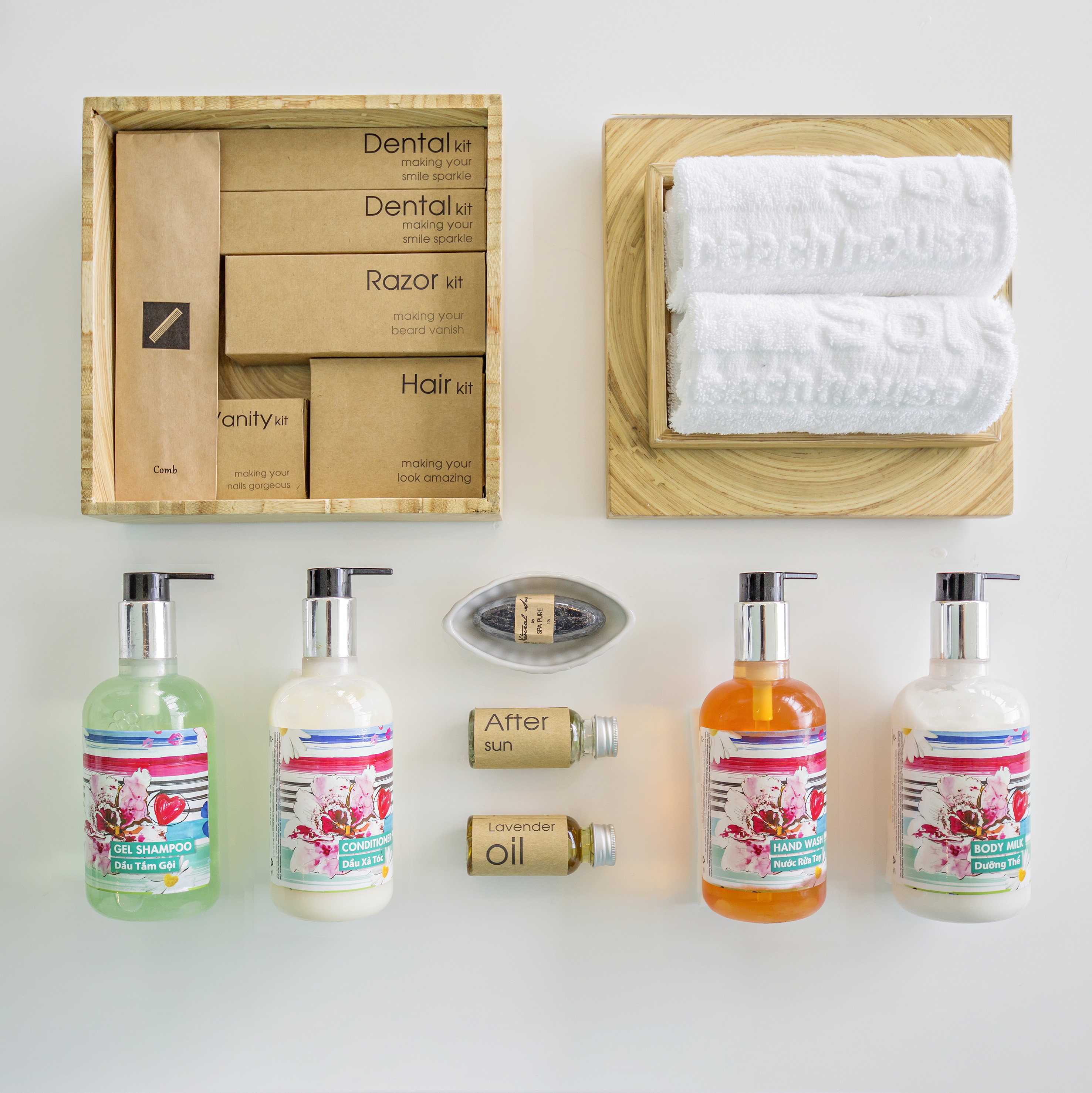 Hotel amenities: shampoo, conditioner, body milk, dental/razor kits, and white towels.