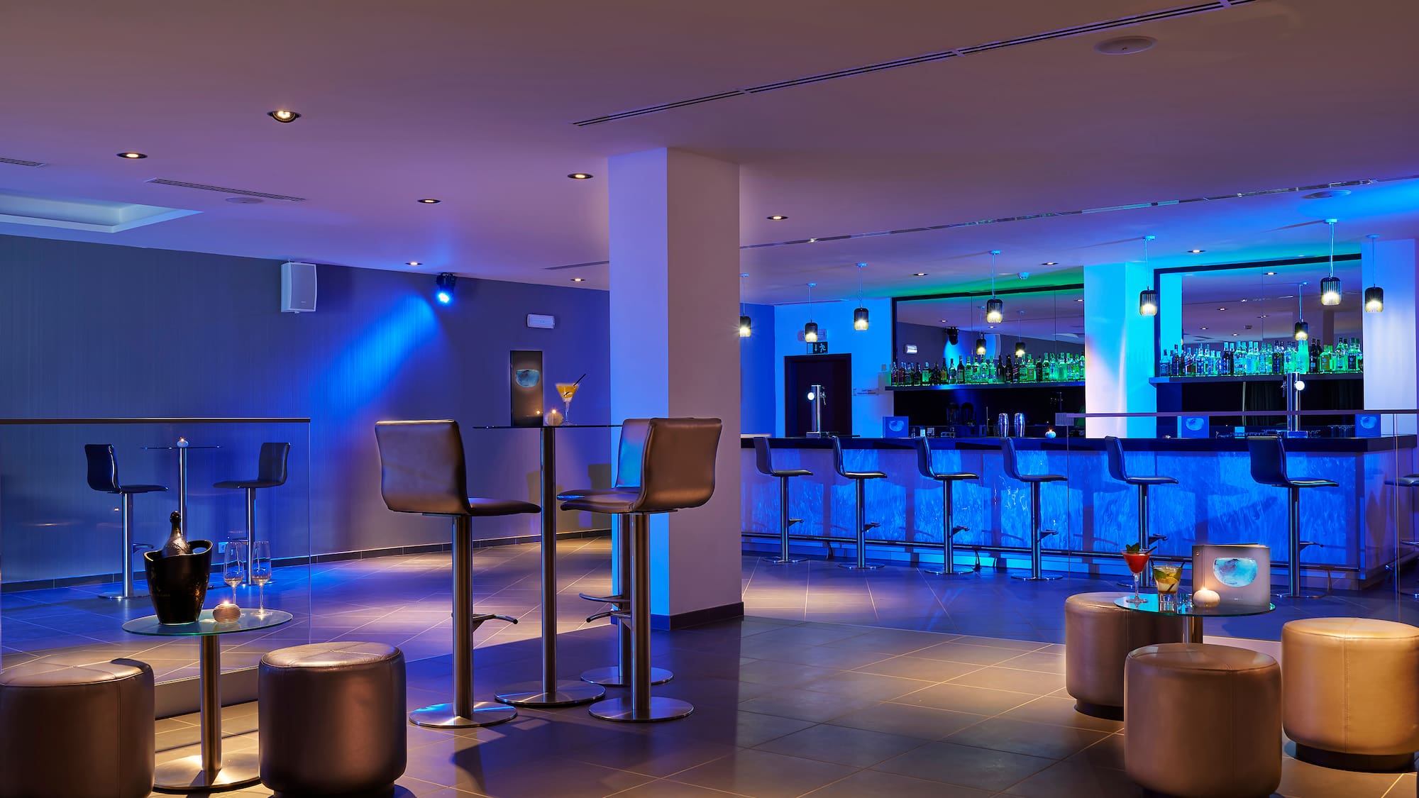 a bar with stools and drinks