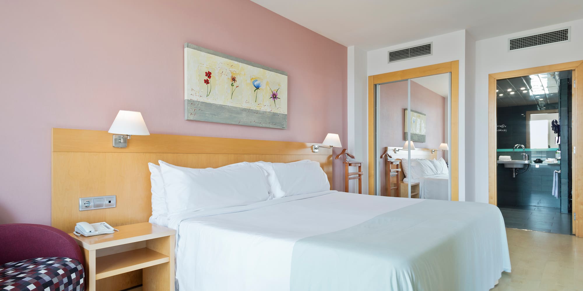 a bed with white sheets and a table