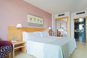 a bed with white sheets and a table