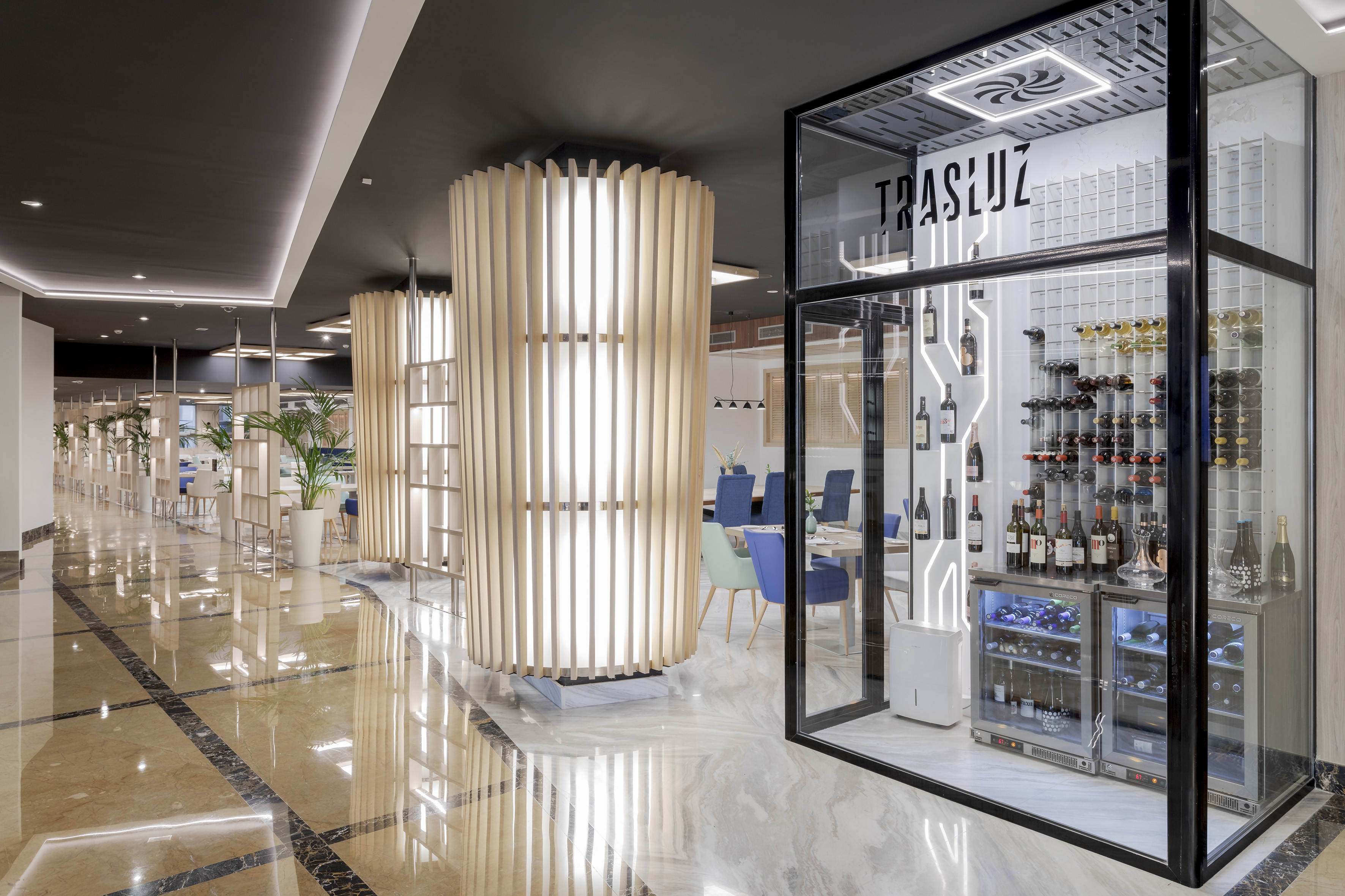 Elegant restaurant interior with glass wine display and illuminated wooden panels.