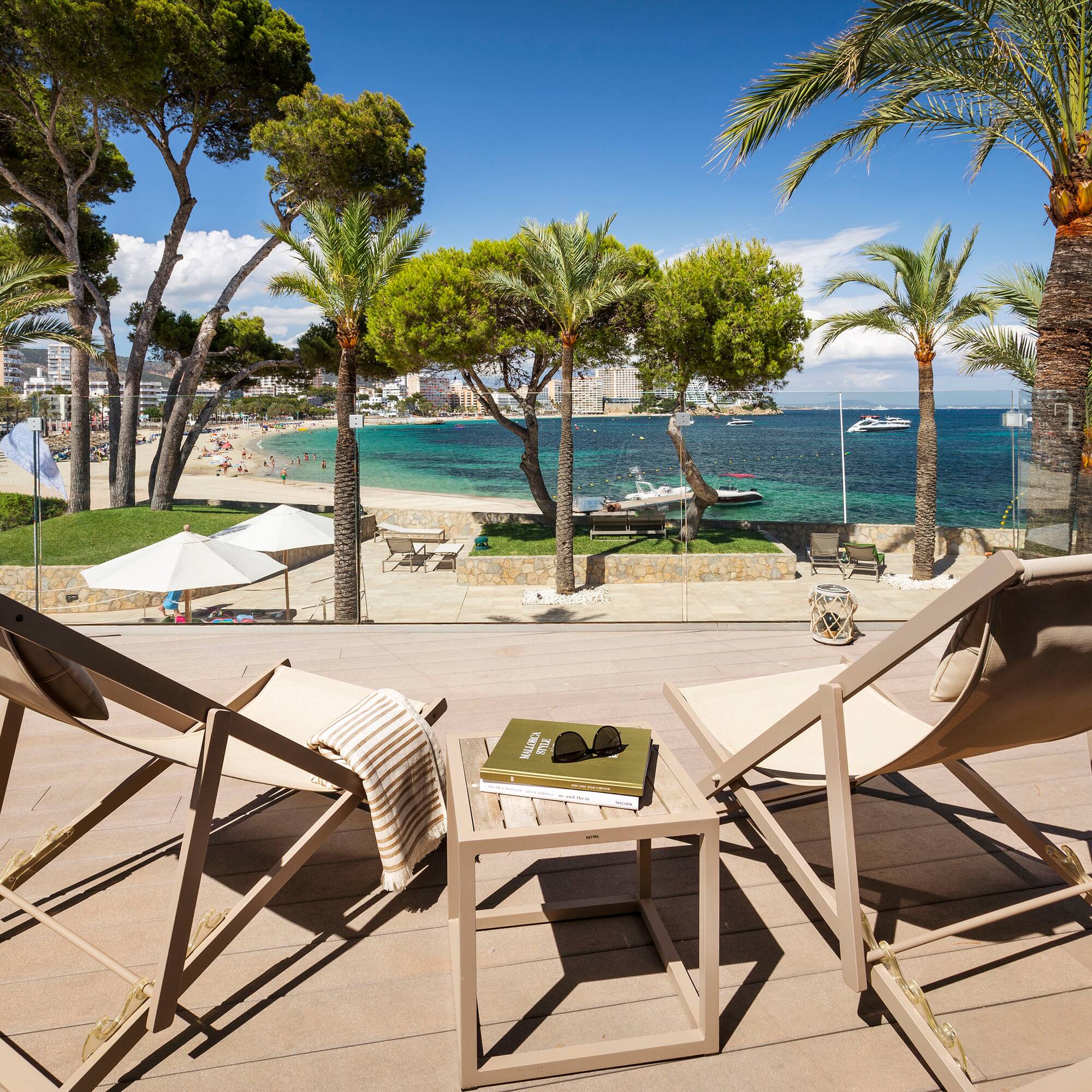 chairs on a deck with palm trees and a beach