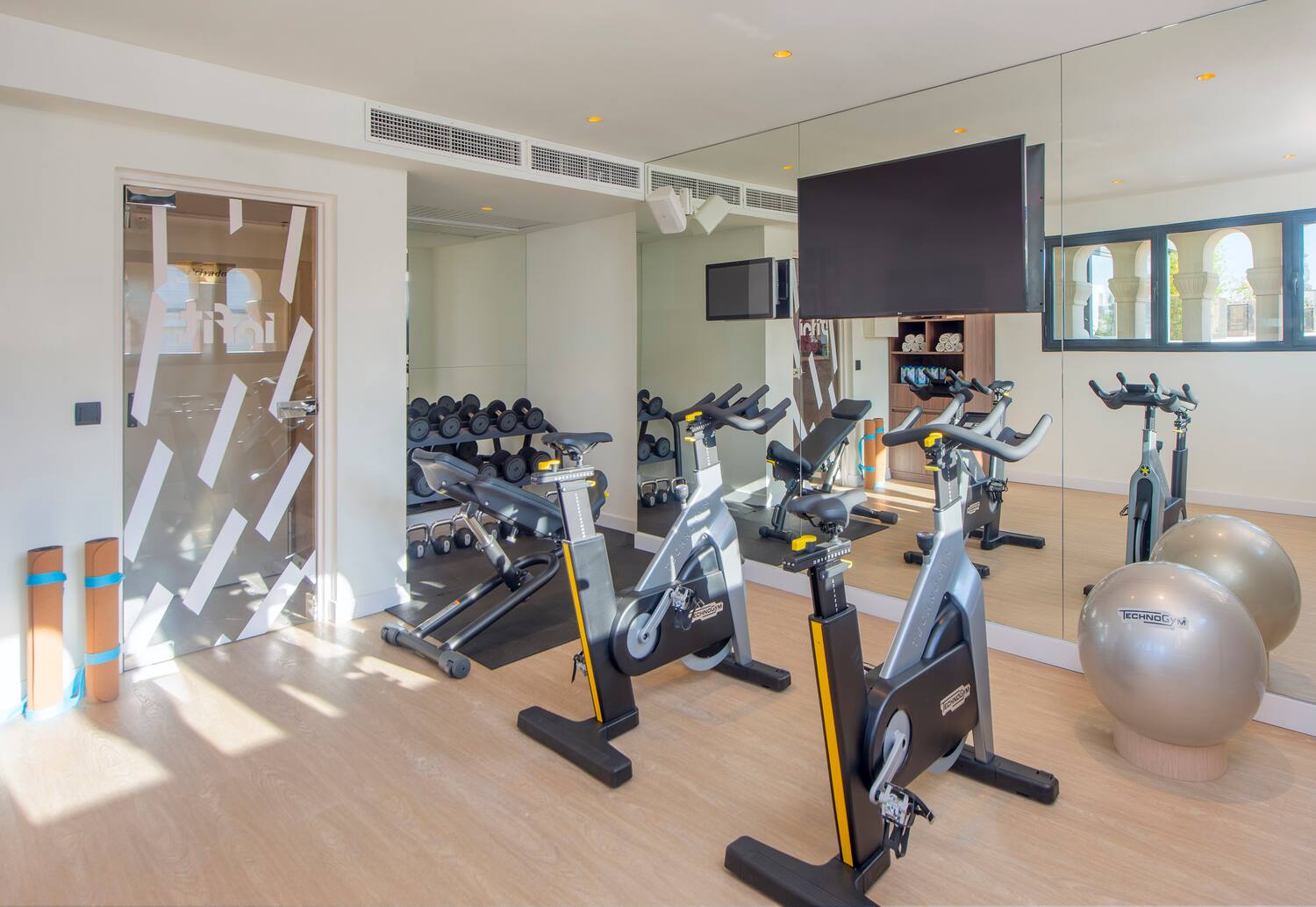 a room with exercise bikes and a mirror