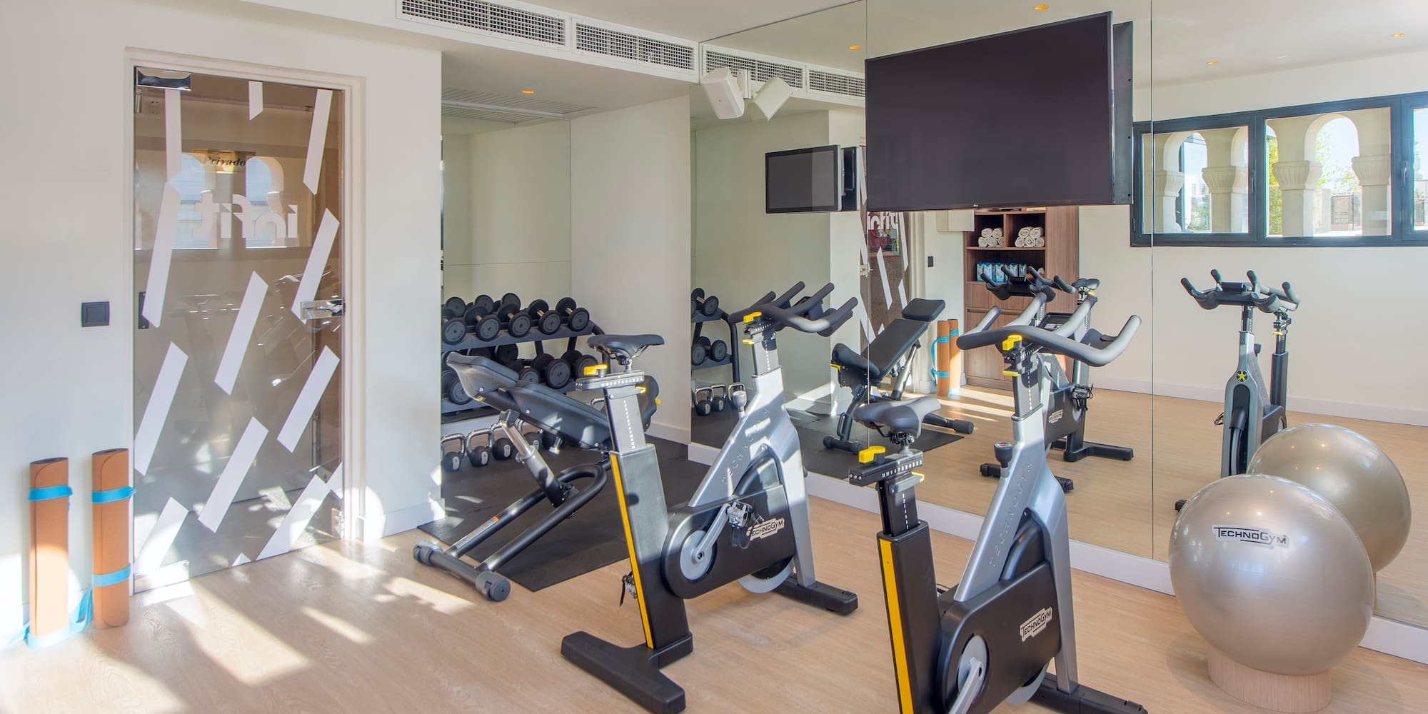 a room with exercise bikes and a mirror