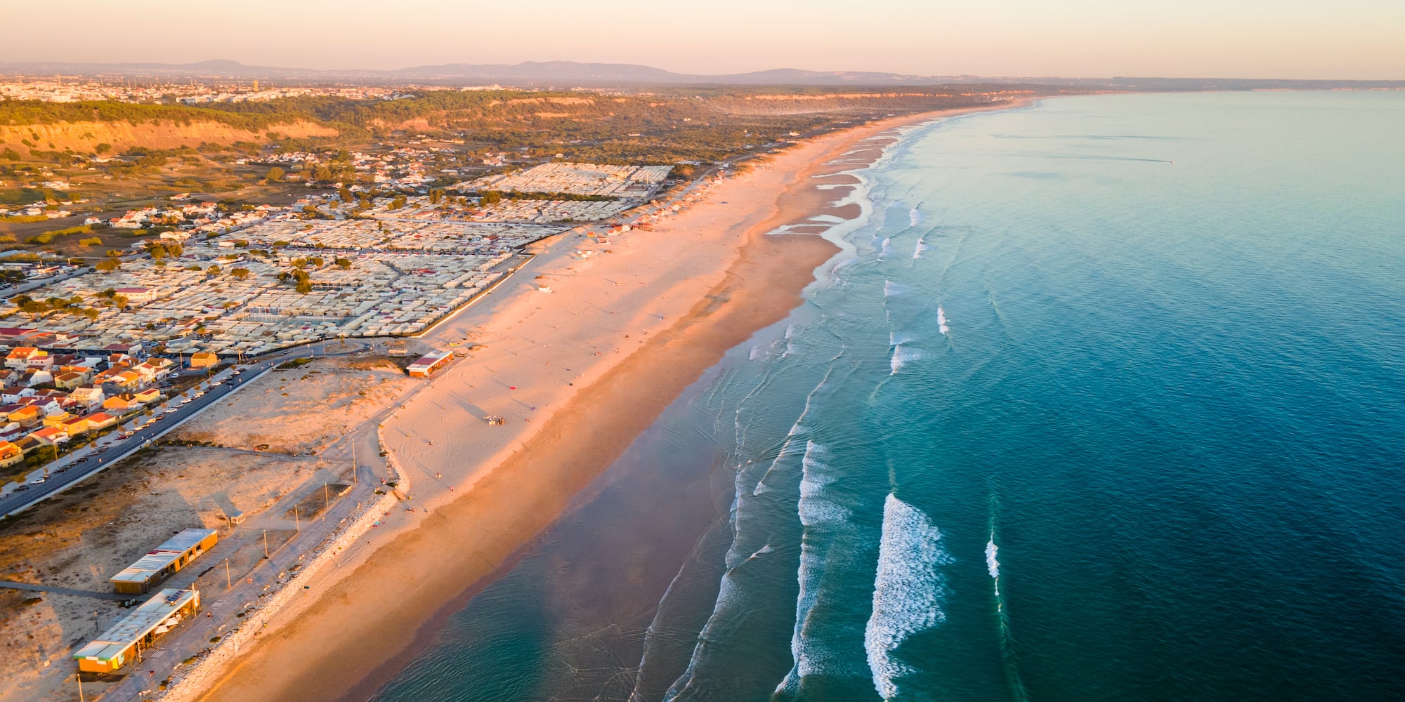a beach with buildings and water