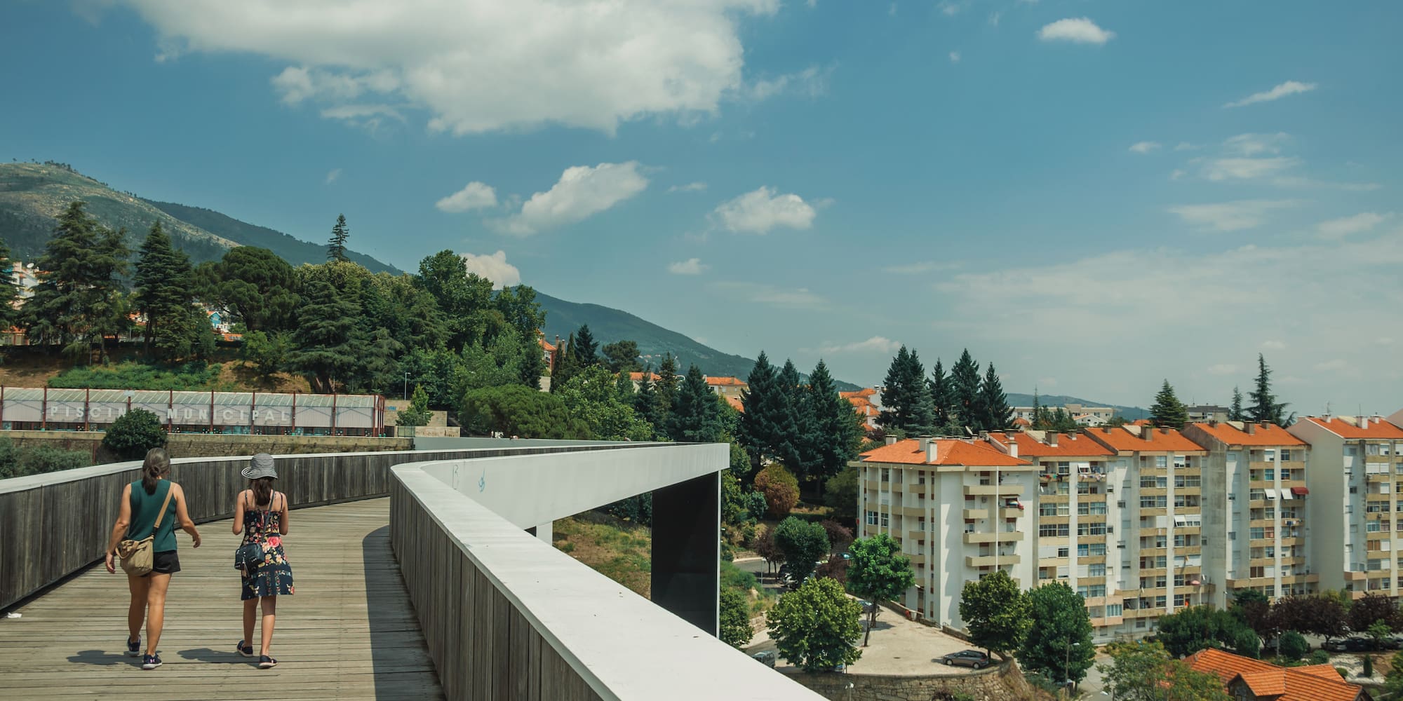 a woman standing on a bridge over a city