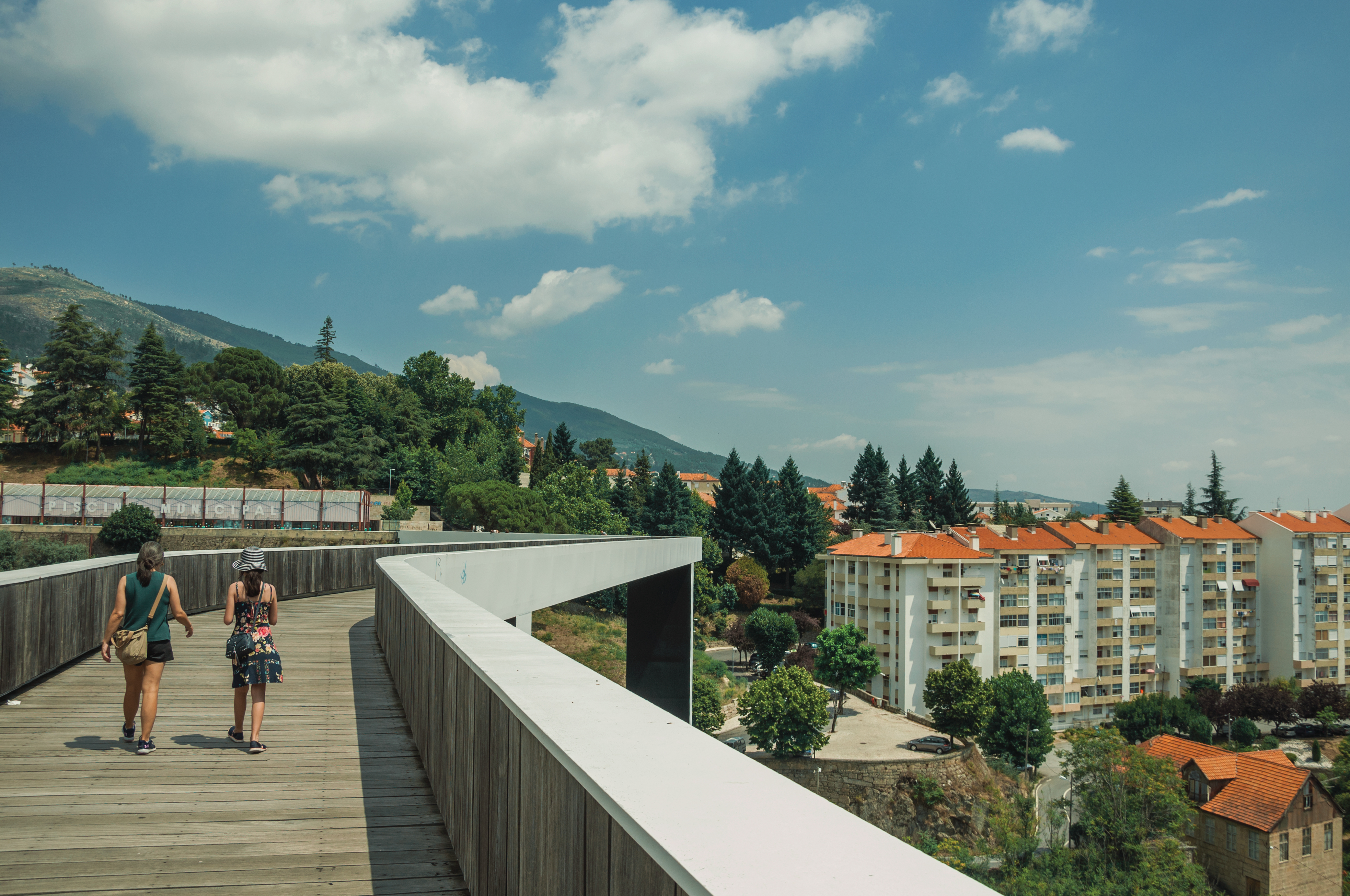 a woman standing on a bridge over a city