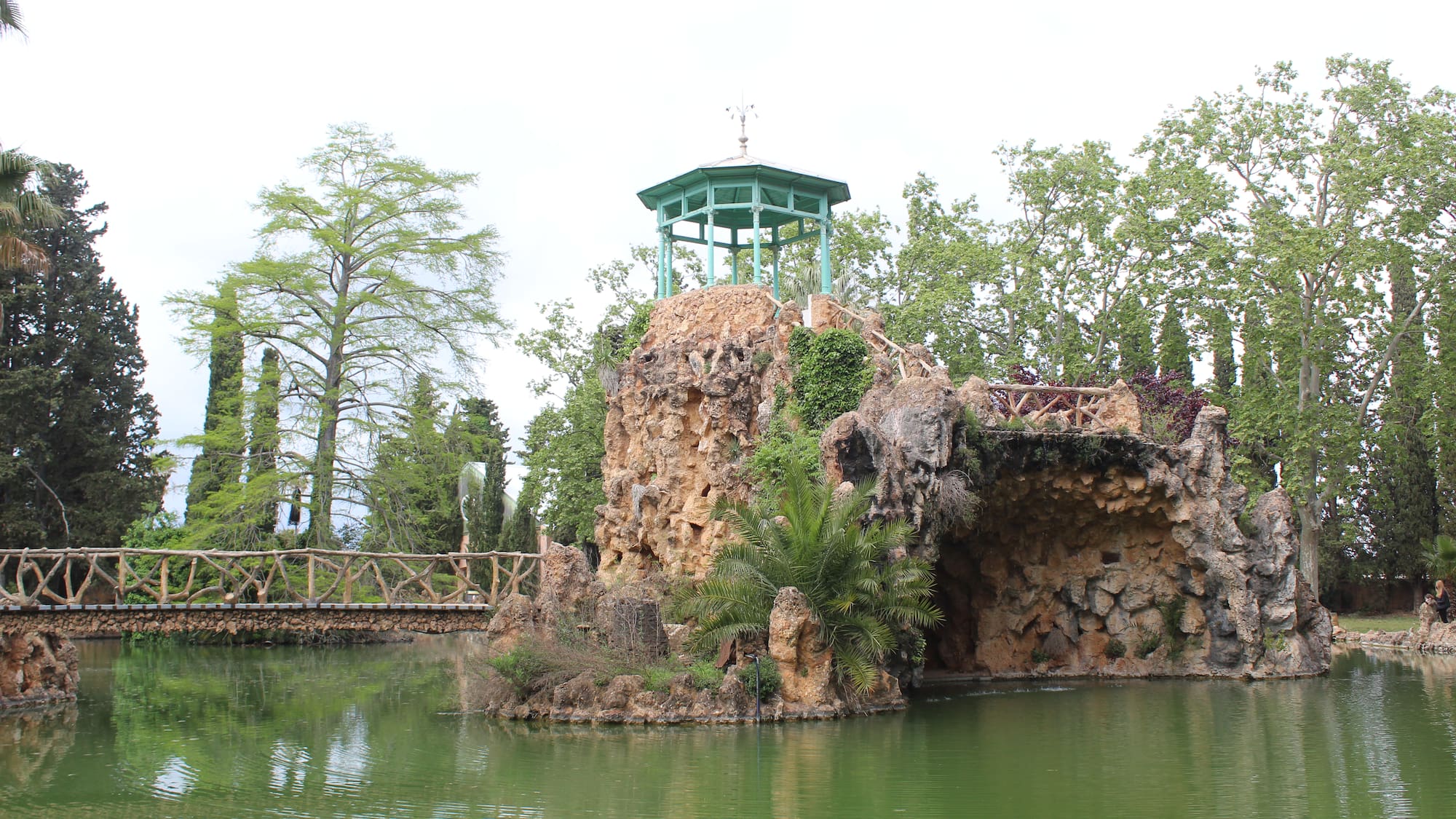 a small rock structure with a bridge over water
