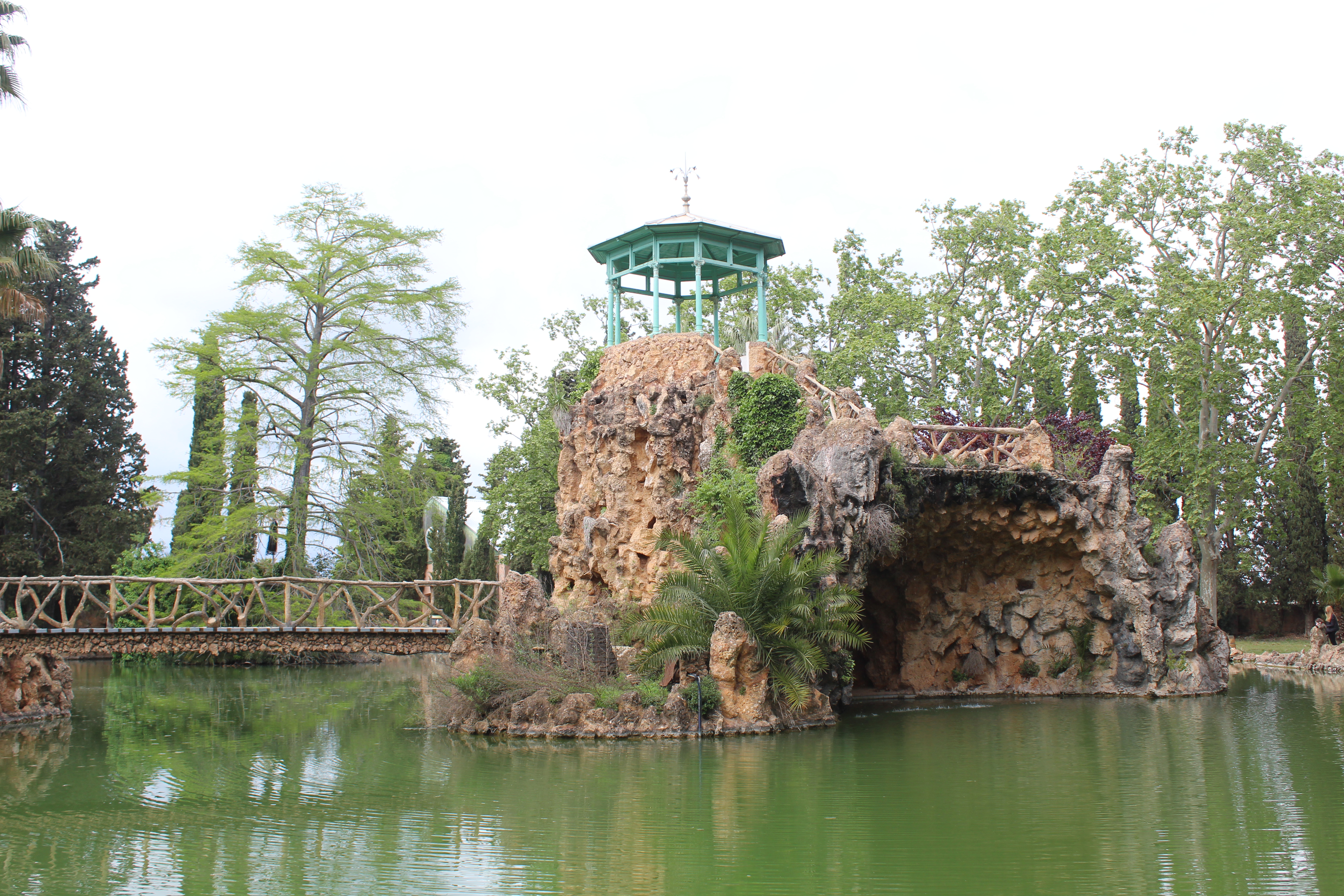 a small rock structure with a bridge over water