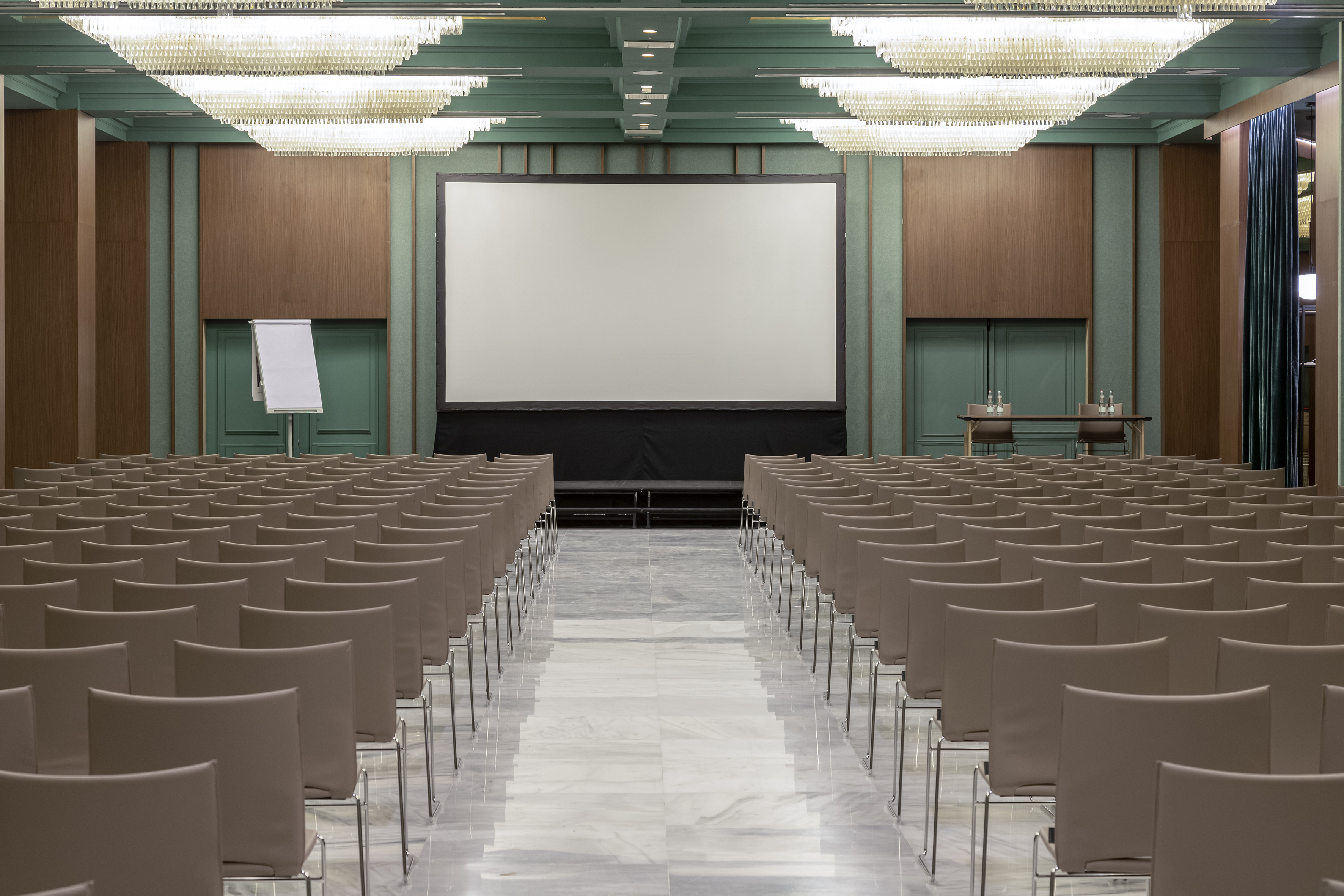 Empty elegant conference room with projection screen and rows of chairs.