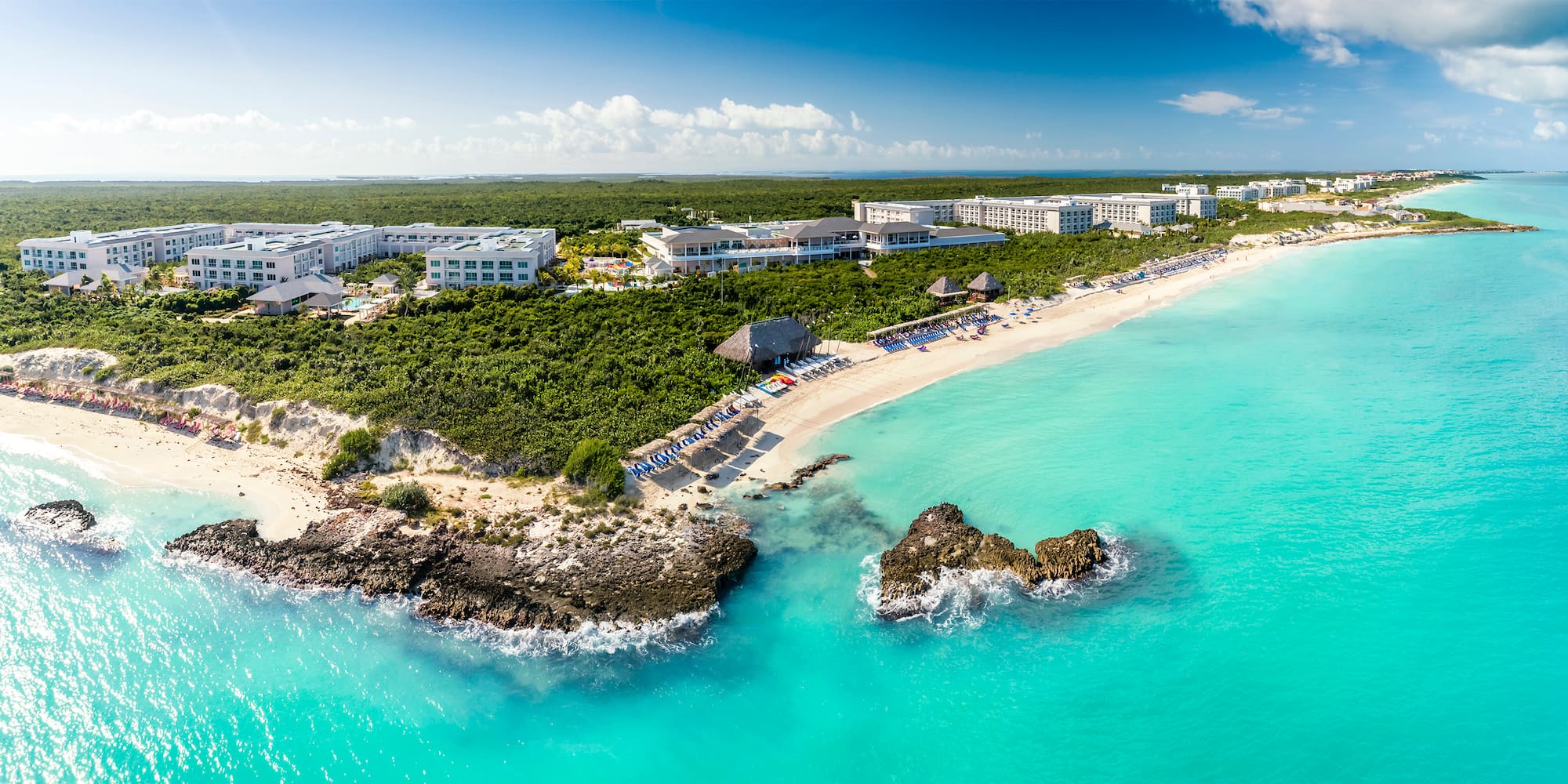 a beach with a group of buildings and a body of water