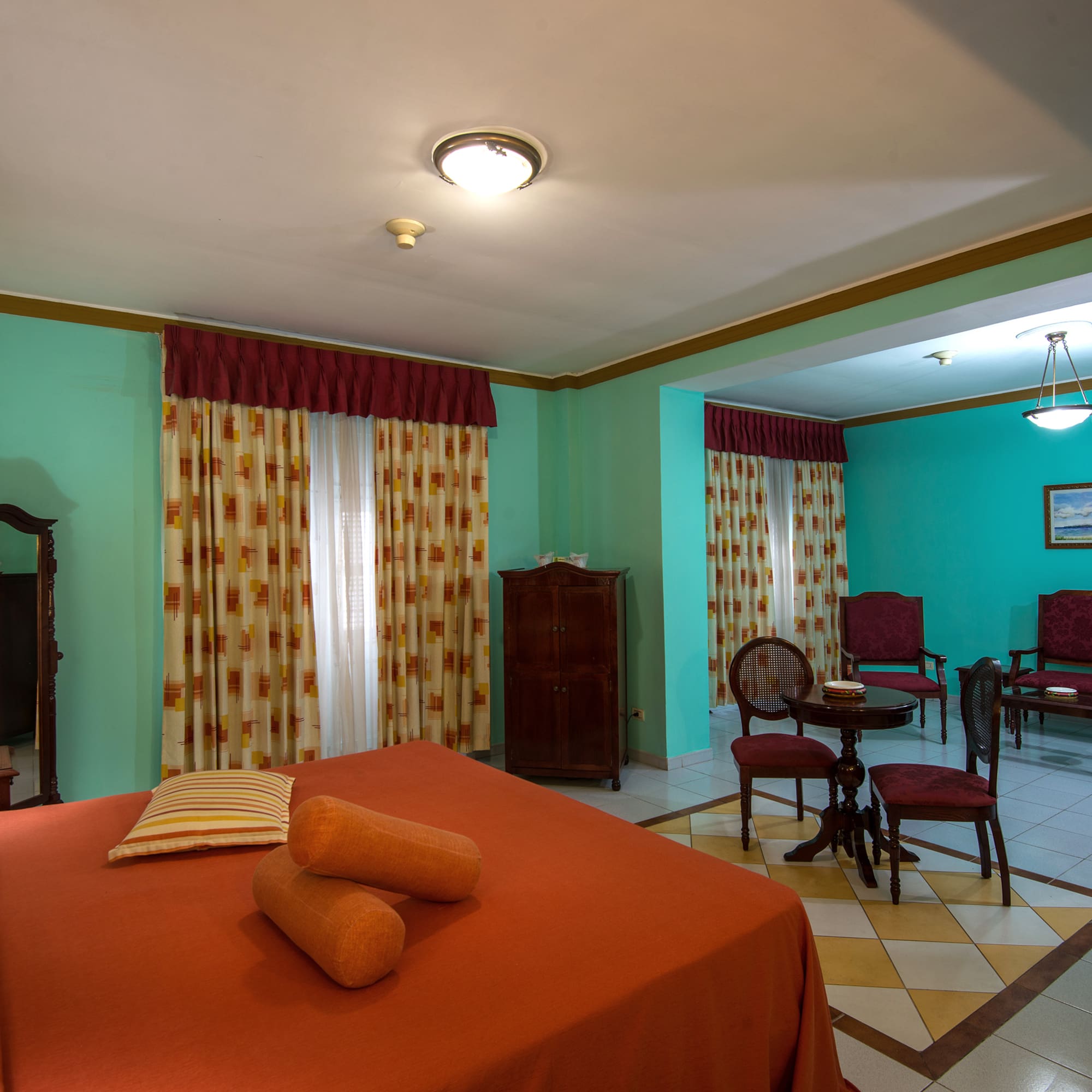 a room with a bed and chairs