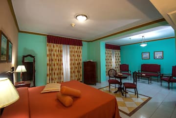 a room with a bed and chairs