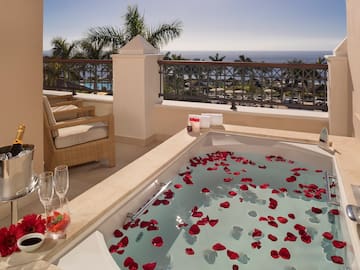 a hot tub with rose petals on the water