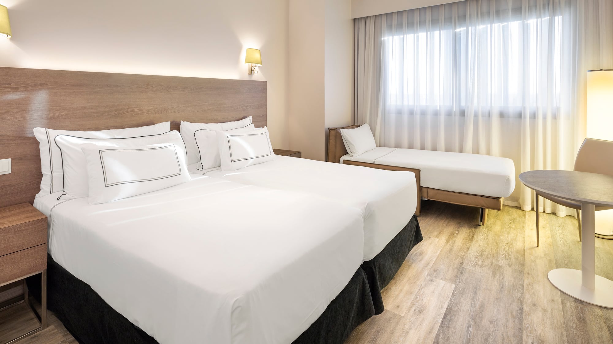 a room with two beds and a wood floor